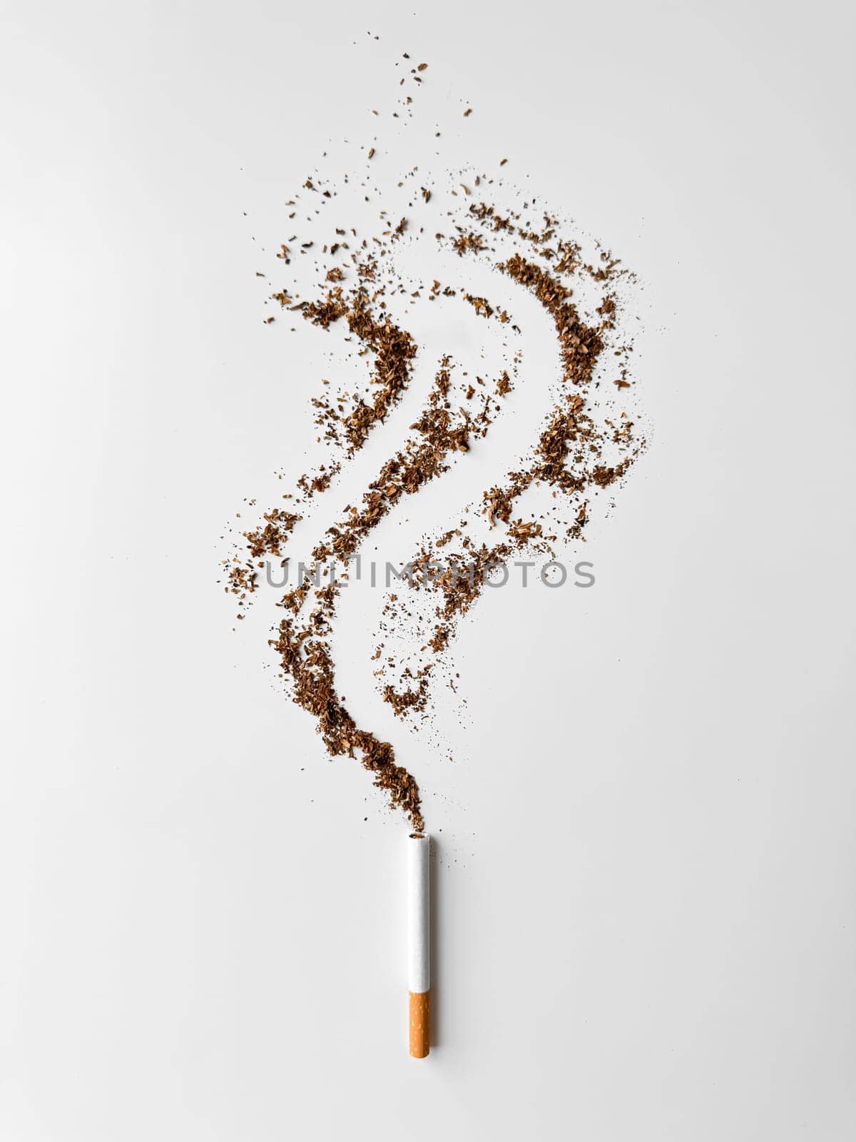 Cigarette with tobacco spilling out in smoke trail shape on white background, symbolizing smoking dangers and health issues. No tobacco day. High quality photo