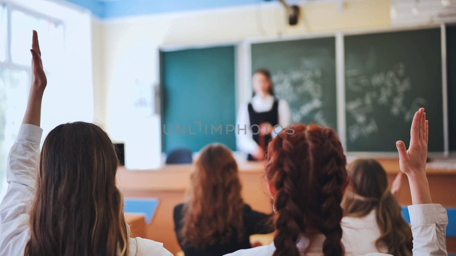 Girl students raise their hands in math class