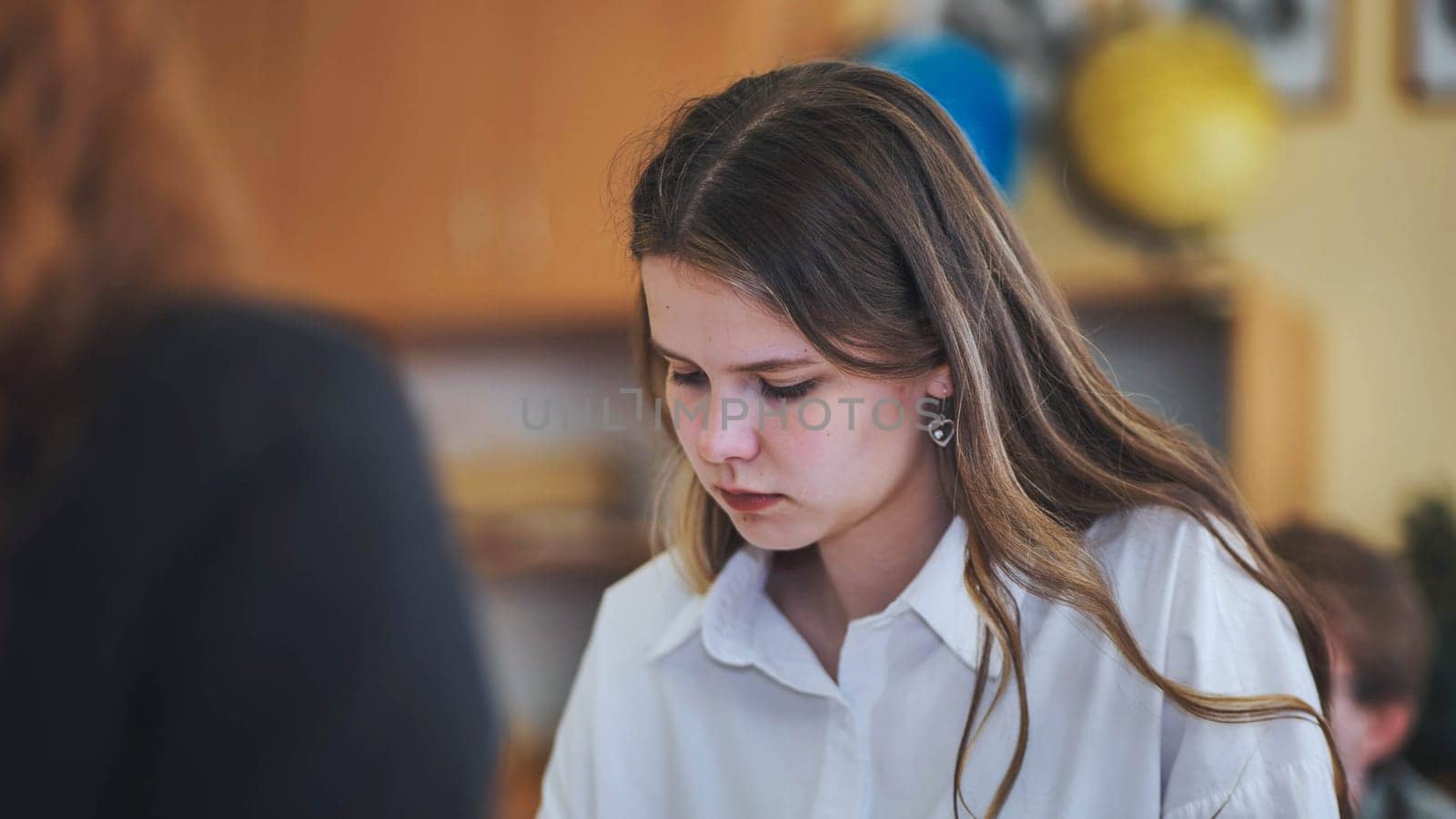 A high school student sits at her desk. by DovidPro