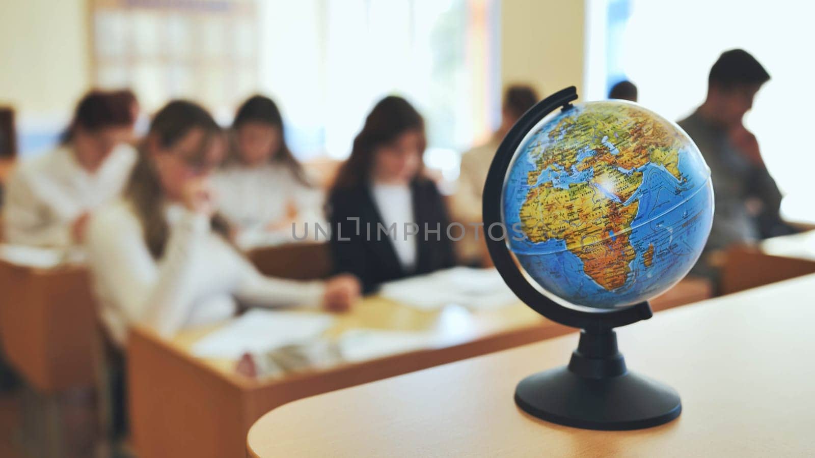 A globe of the world in a school classroom during a lesson. The globe shows Africa and Eurasia. by DovidPro