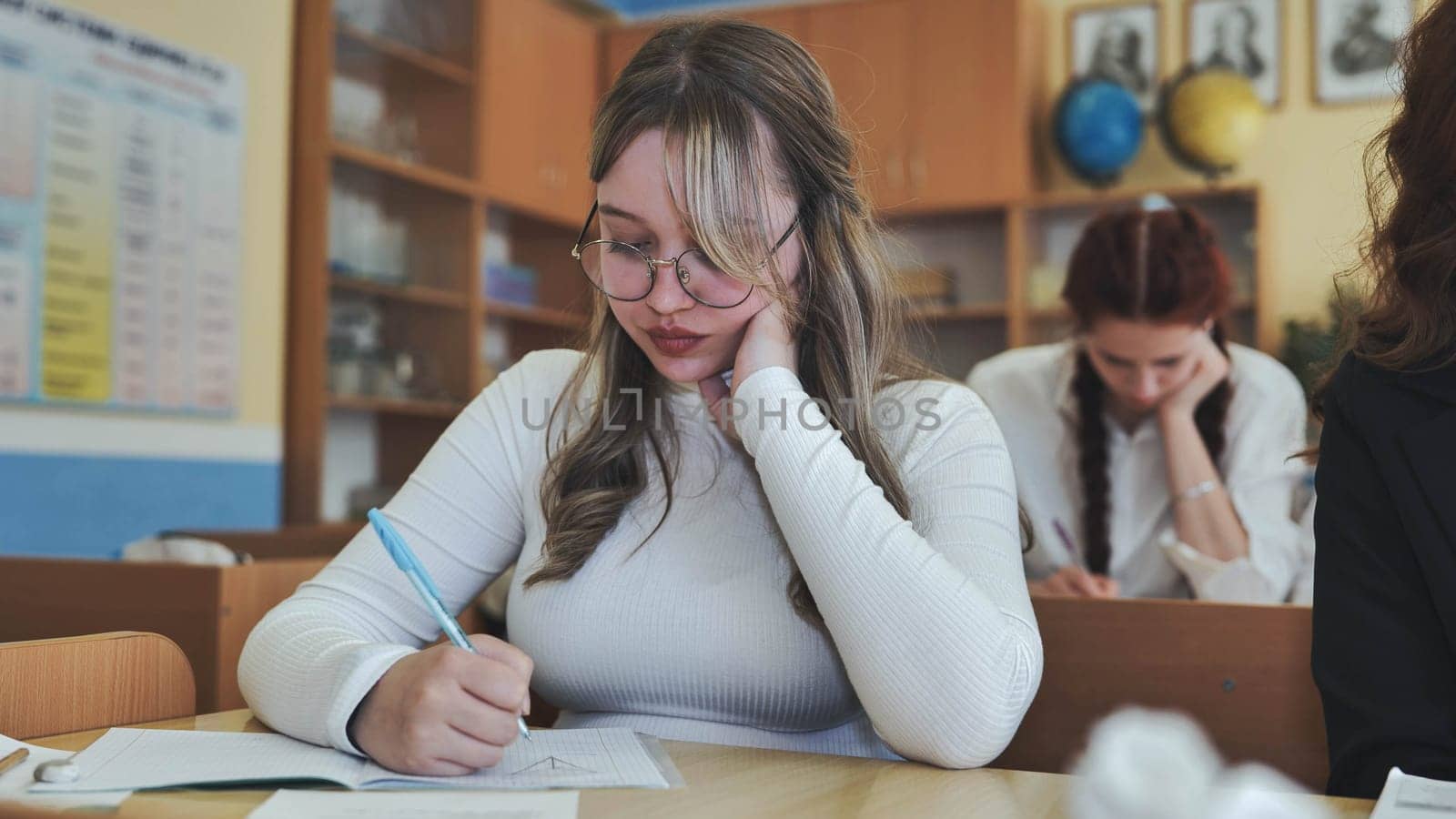 A high school student sits at her desk