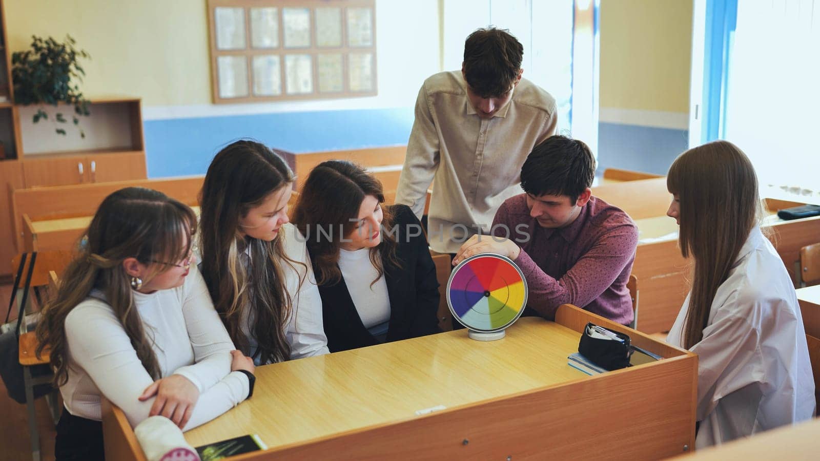 Students in physics class spin Newton's colorful wheel.