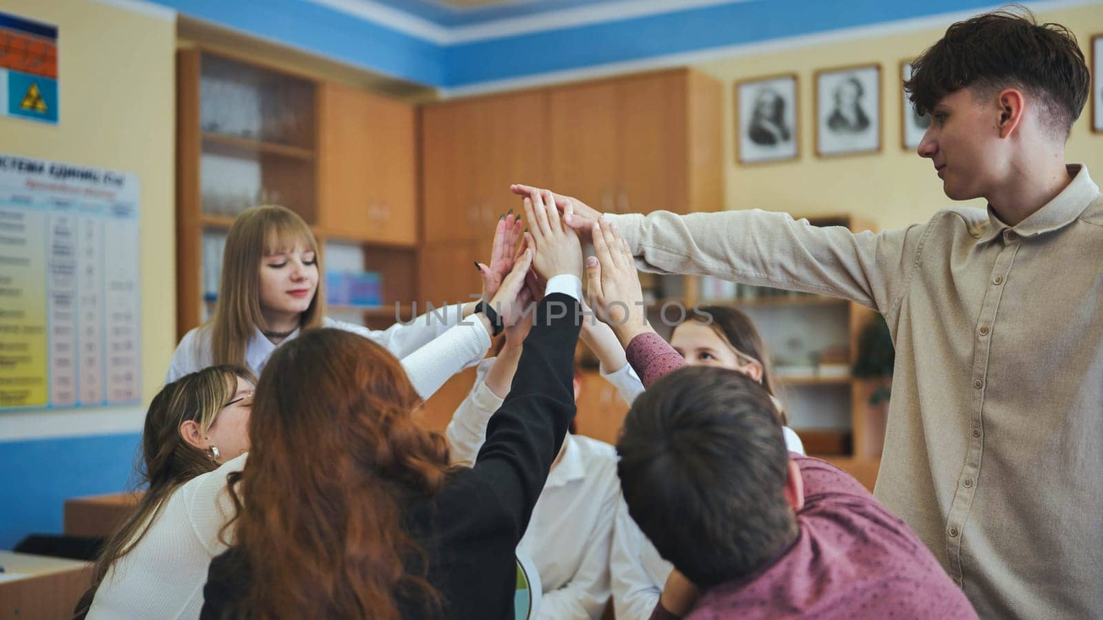 High school seniors join hands in class as a sign of working together