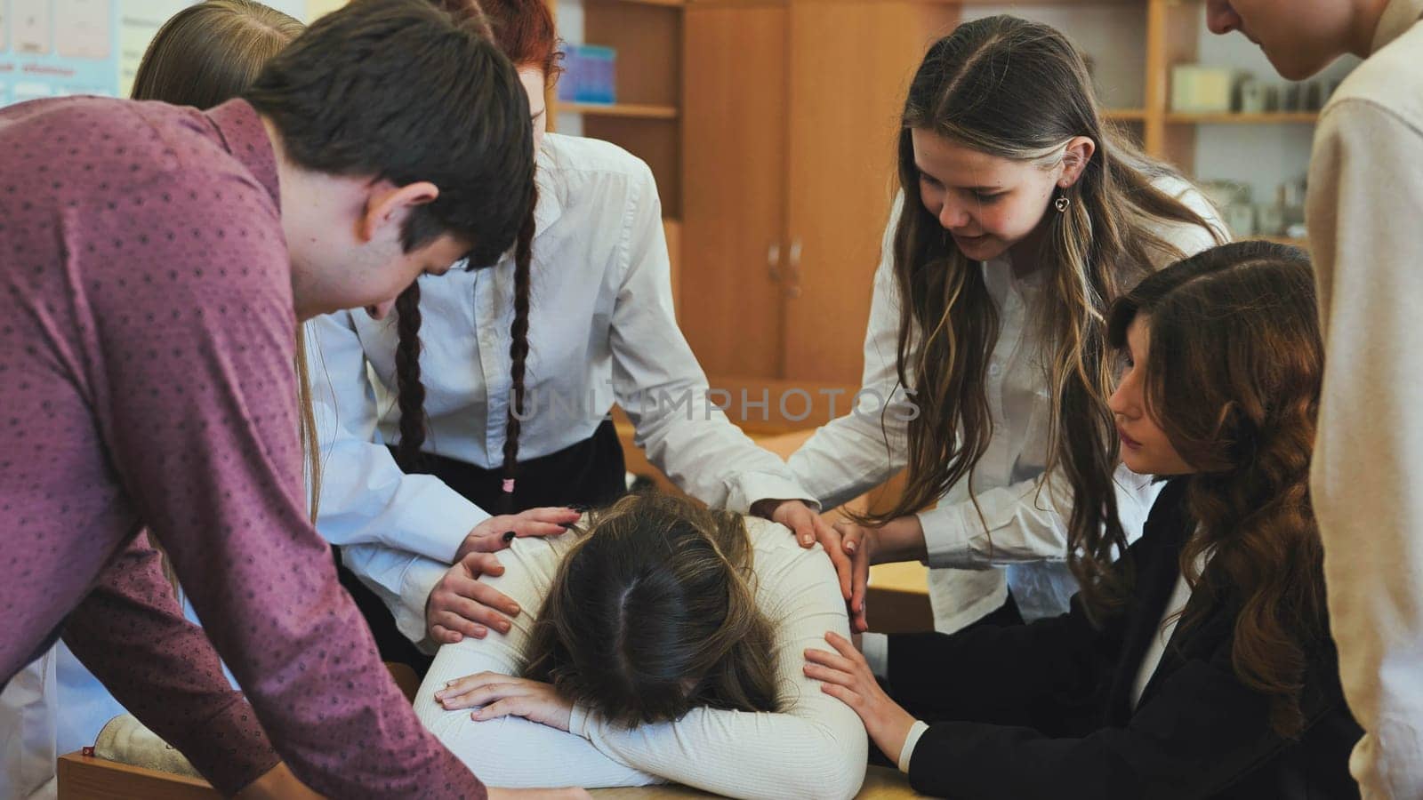 A high school girl cries and her friends comfort her. by DovidPro