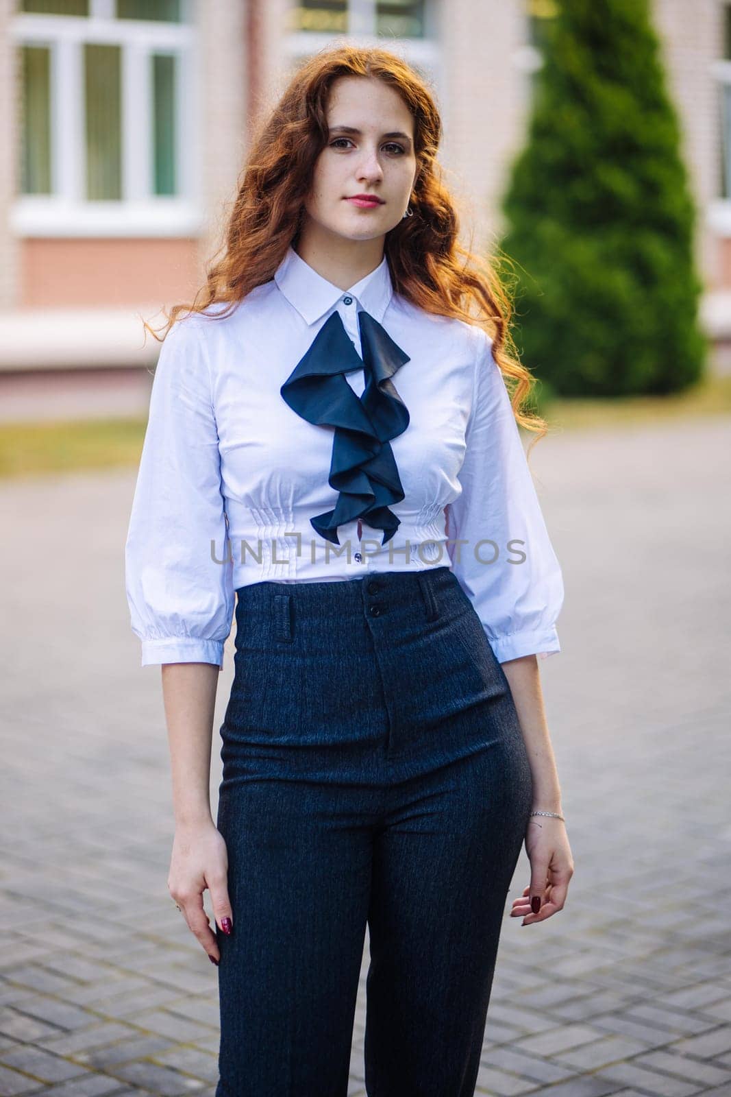 Portrait of a high school student against the backdrop of the school