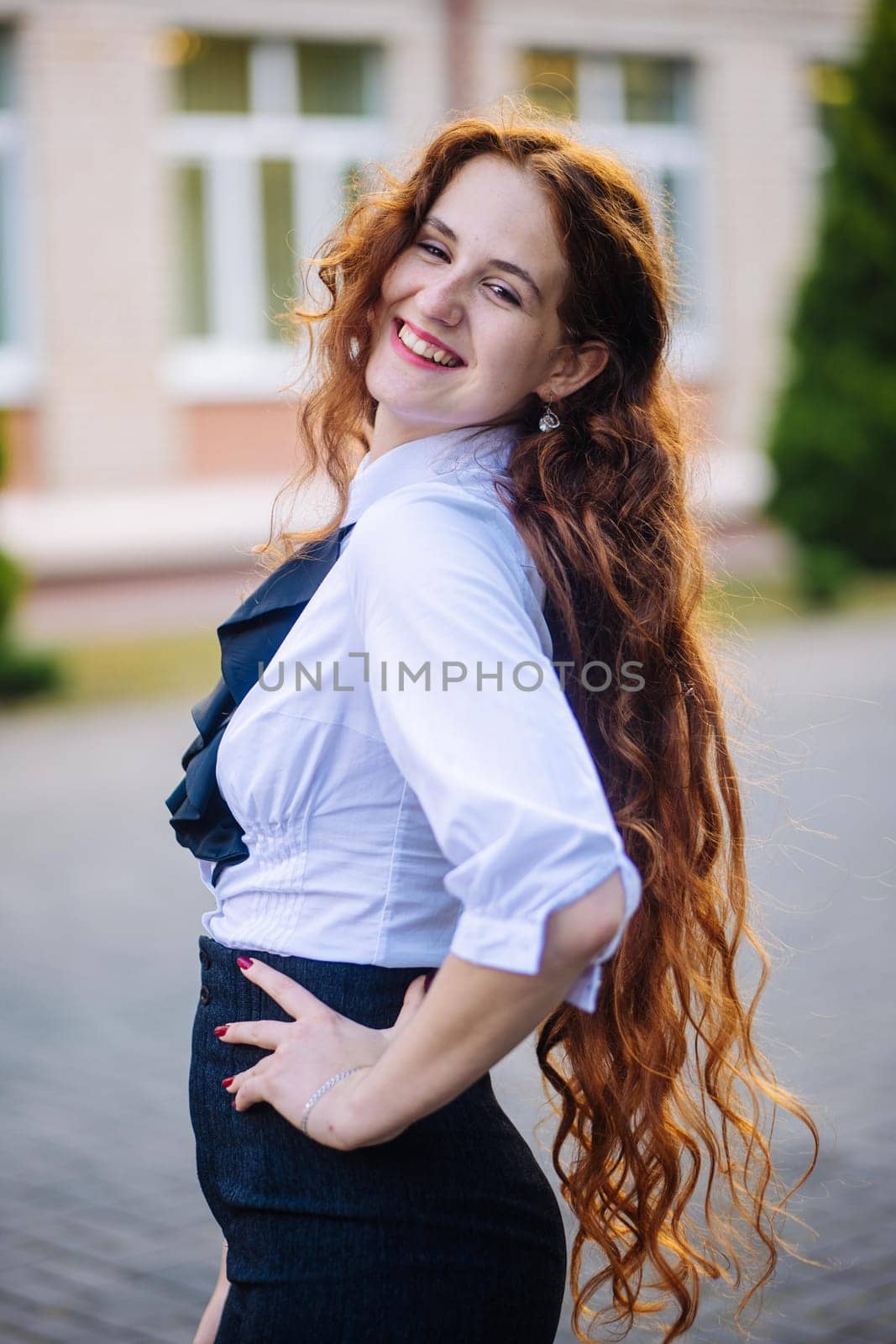 Portrait of a redhead high school student against the backdrop of the school. by DovidPro