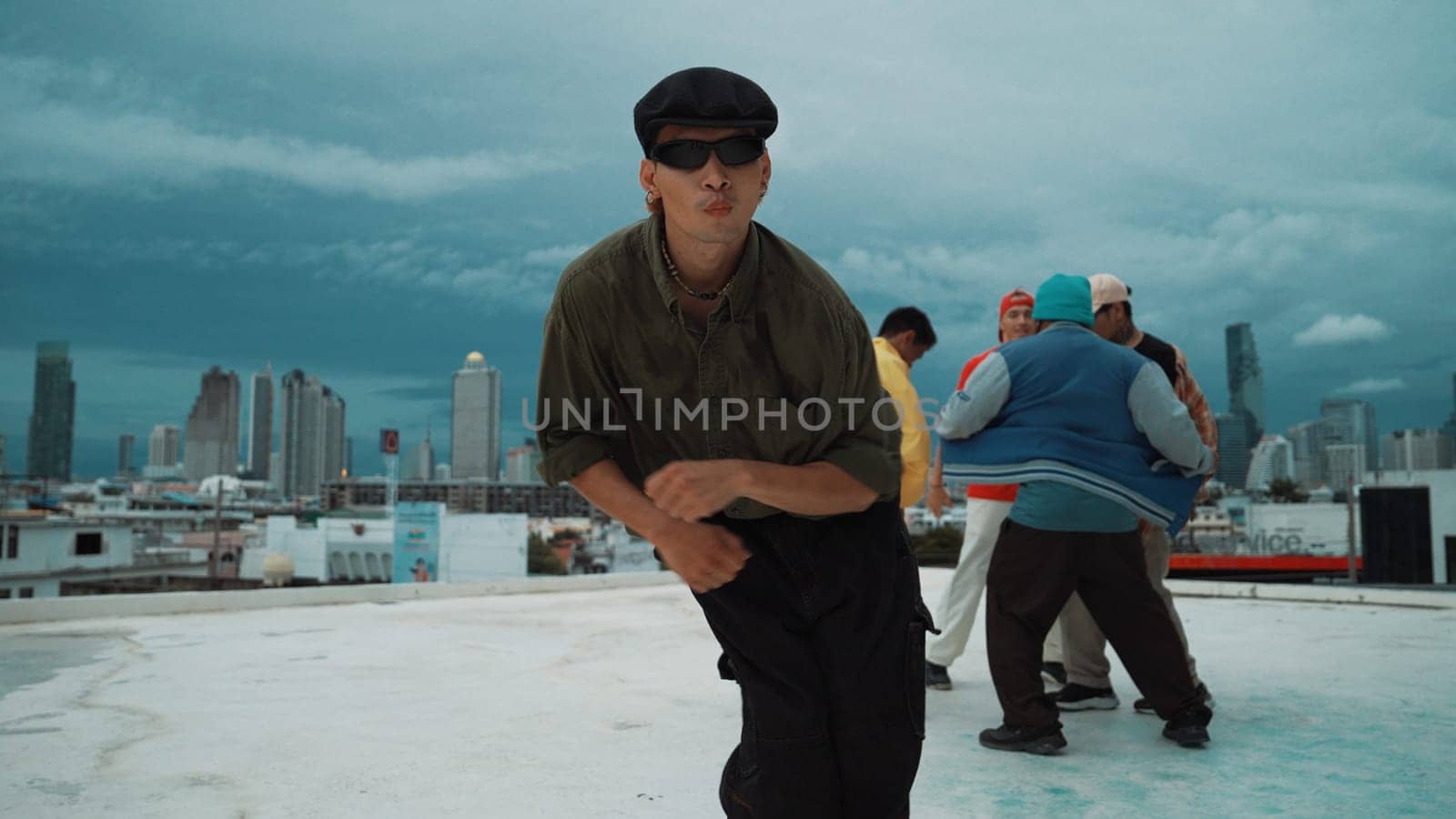 Professional asian dancer practice B boy dance while multicultural friends dancing at roof top. Young modern dancing group doing hip hop movement. Style,fashion,action. Outdoor sport 2024. Endeavor.