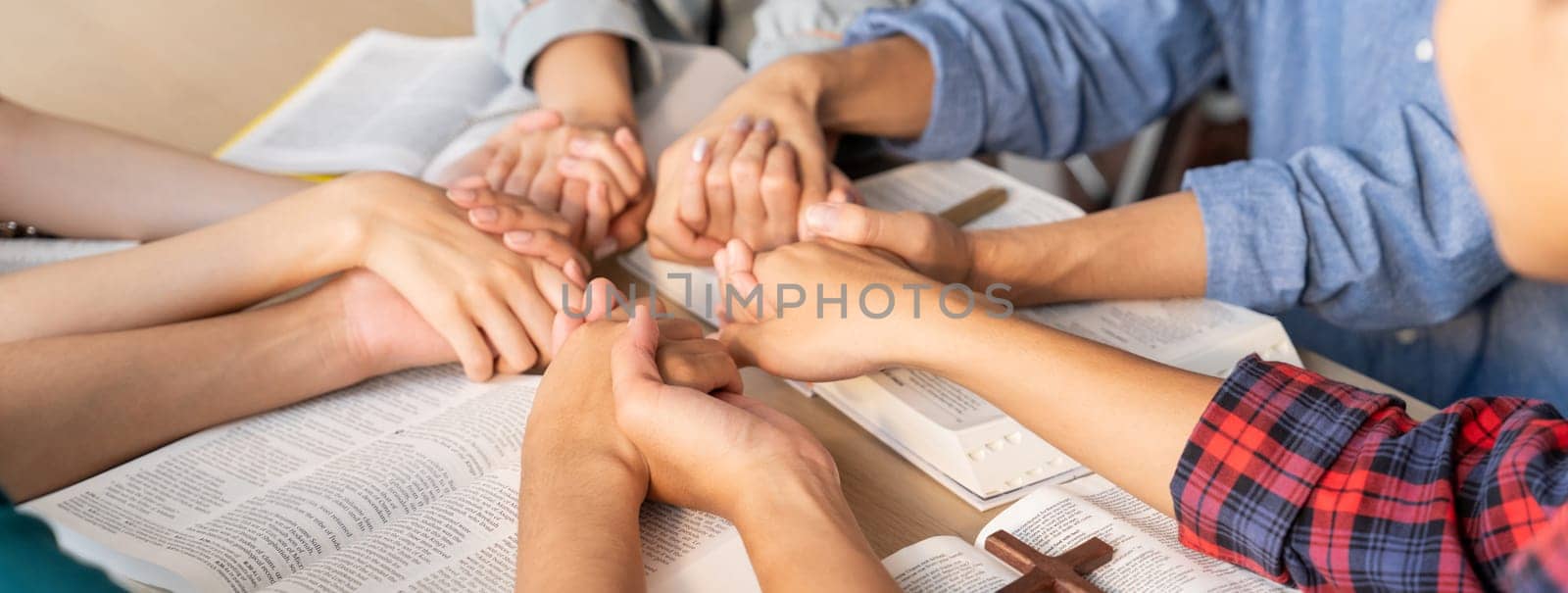 Believer hand praying together on bible book while holding hand. Burgeoning by biancoblue