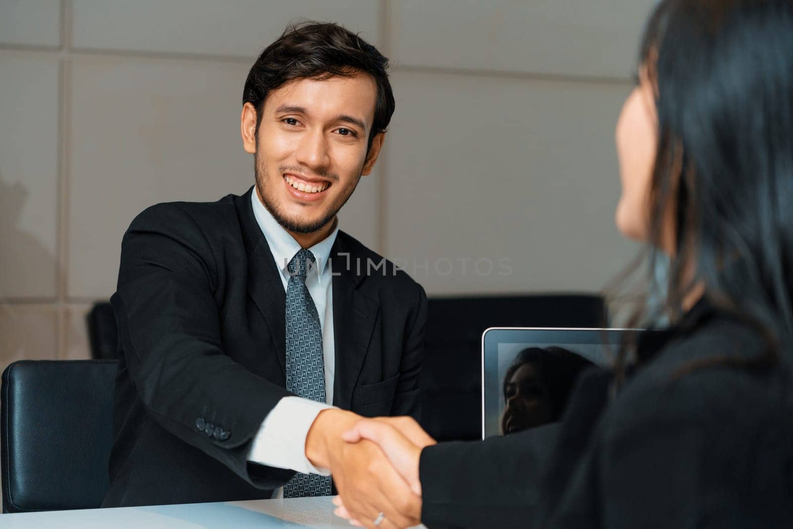 Business people agreement concept. Businessman and Asian businesswoman do handshake in the office. uds