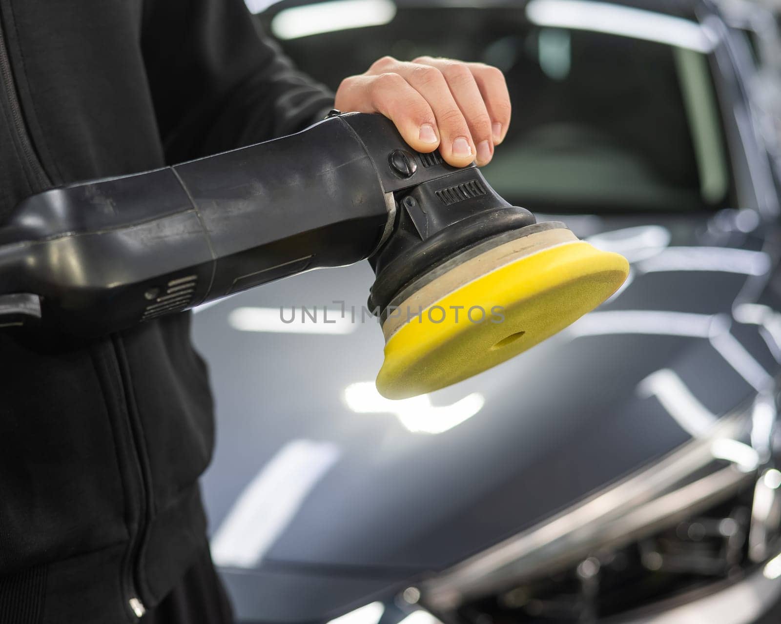 A master holds a device for polishing the surface of a car body