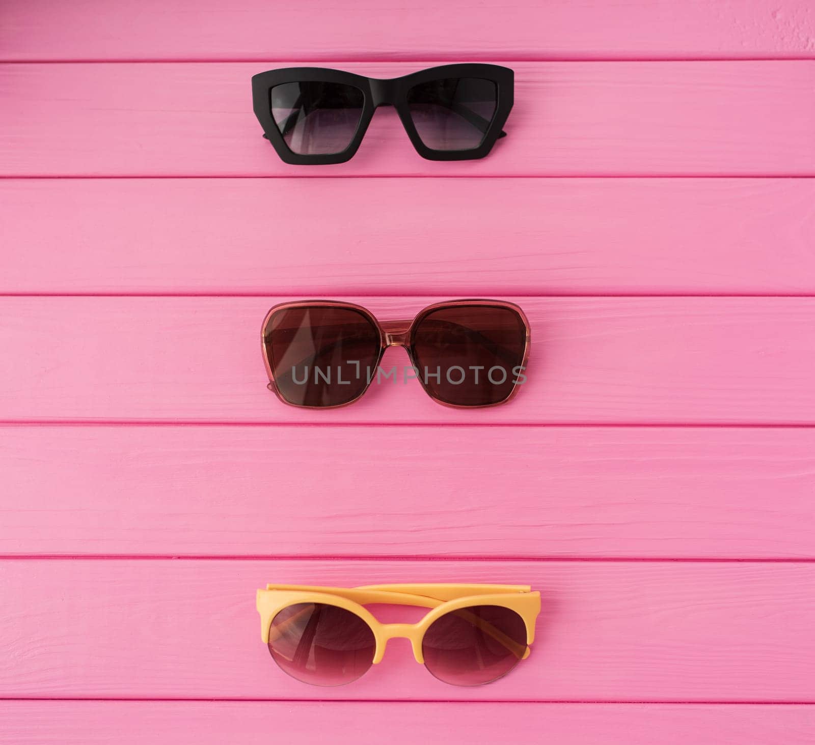 Summer abstract background mockup template free copy space for text pattern sample top view above on pink wooden board. blank empty area for inscription. Couple Stylish black sunglasses fashionable