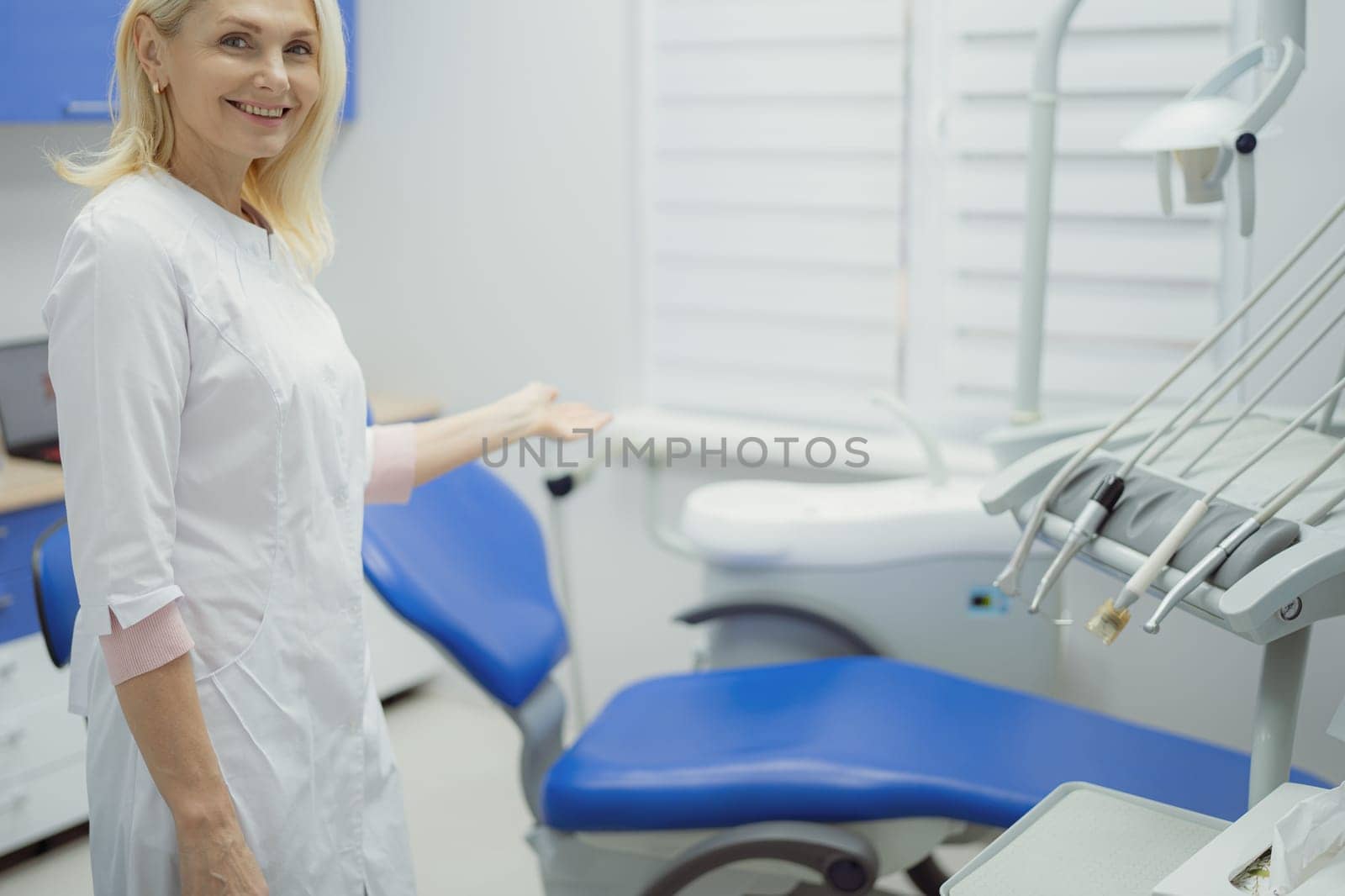Woman working in dental clinic and doctor in background. by Сookiestock