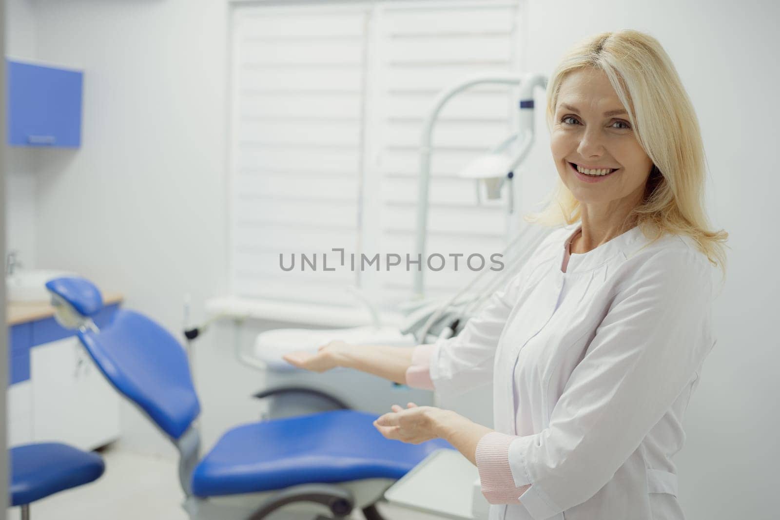 Woman working in dental clinic and doctor in background.