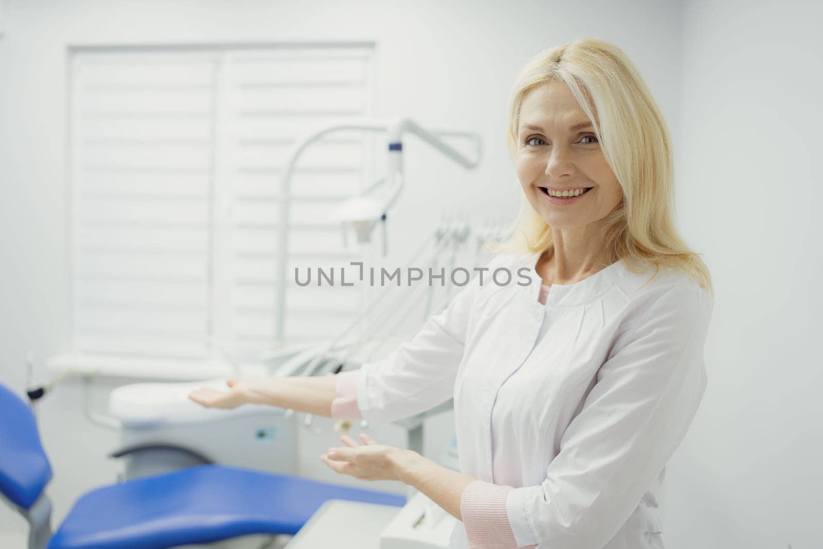 Woman working in dental clinic and doctor in background.