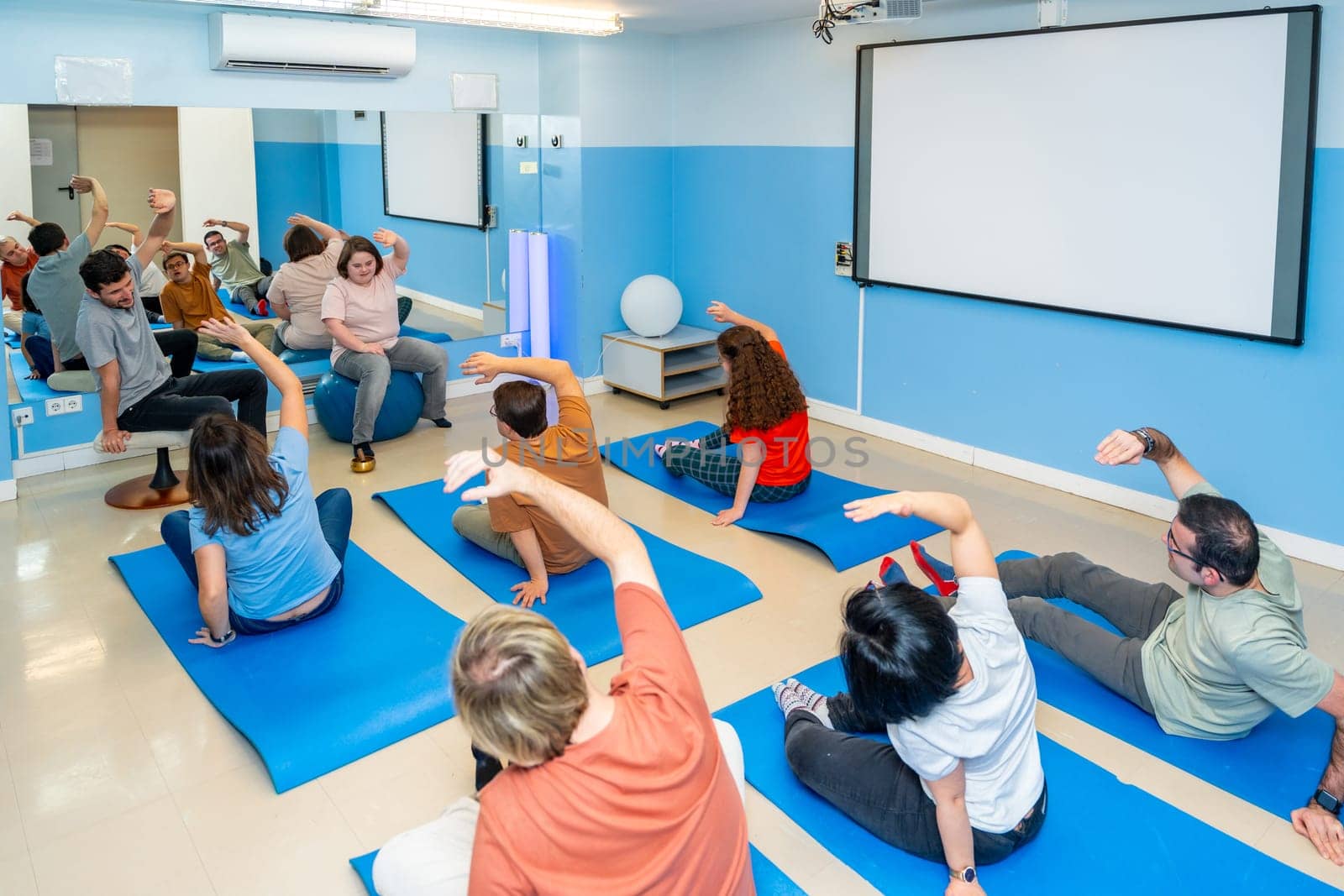 Disabled people stretching during yoga class together by Huizi