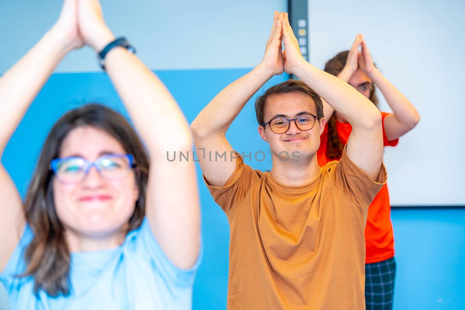 Disabled people raising arms practicing yoga in the gym by Huizi