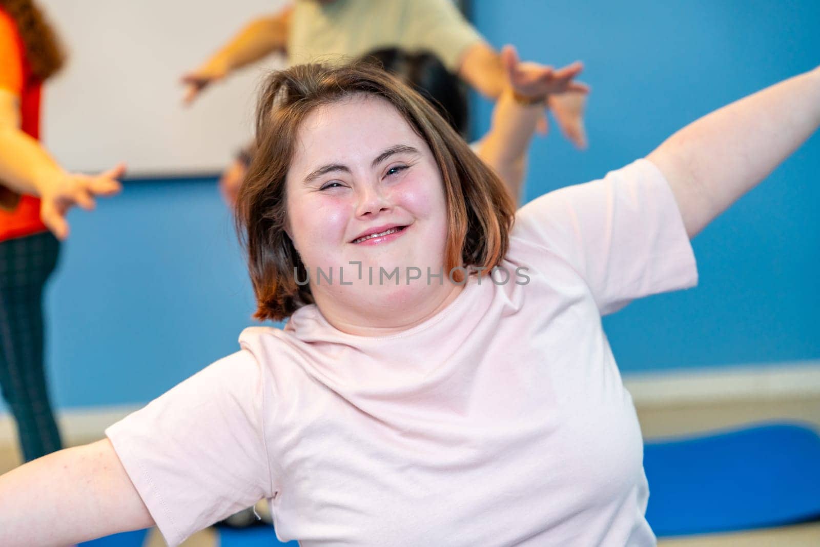 Woman with down syndrome smiling at camera in the gym by Huizi