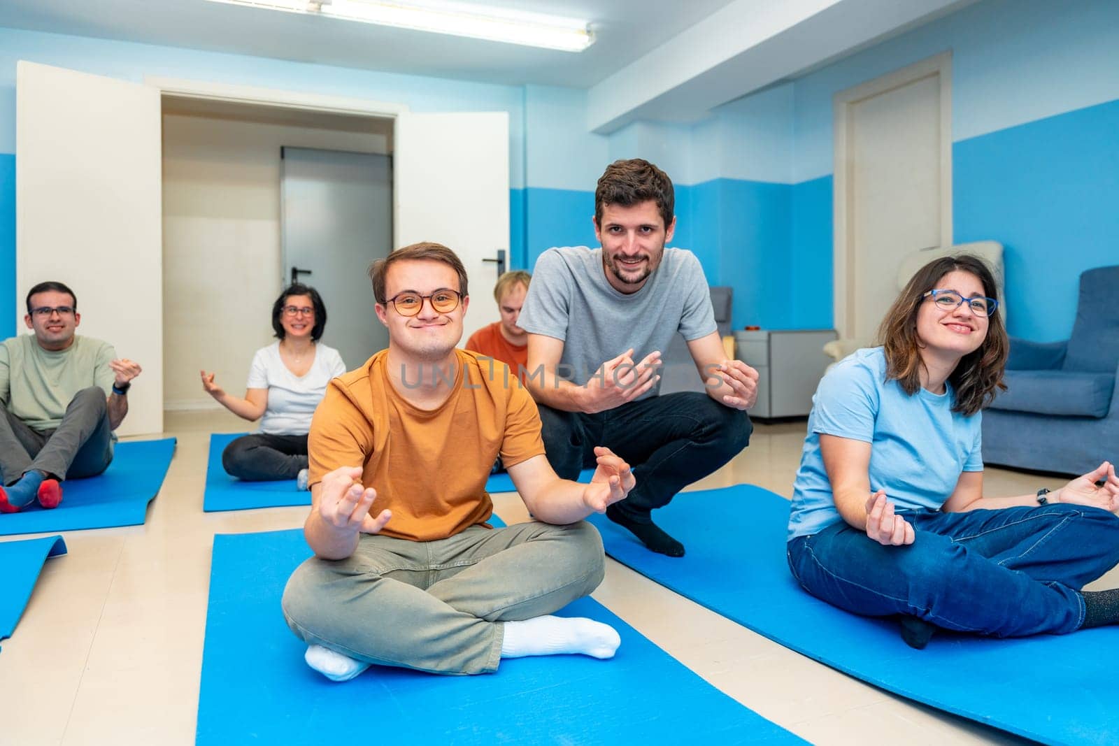 Yoga instructor directing a class with people with special needs by Huizi