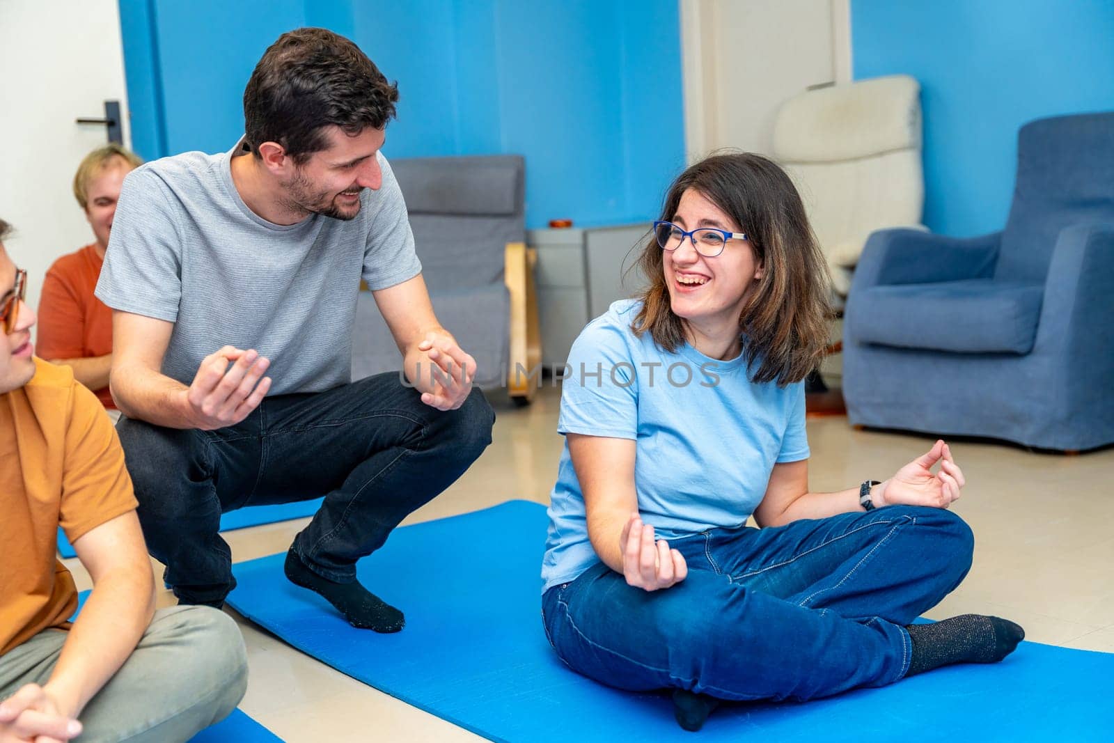 Yoga instructor teaching the lotus position to a disabled woman by Huizi