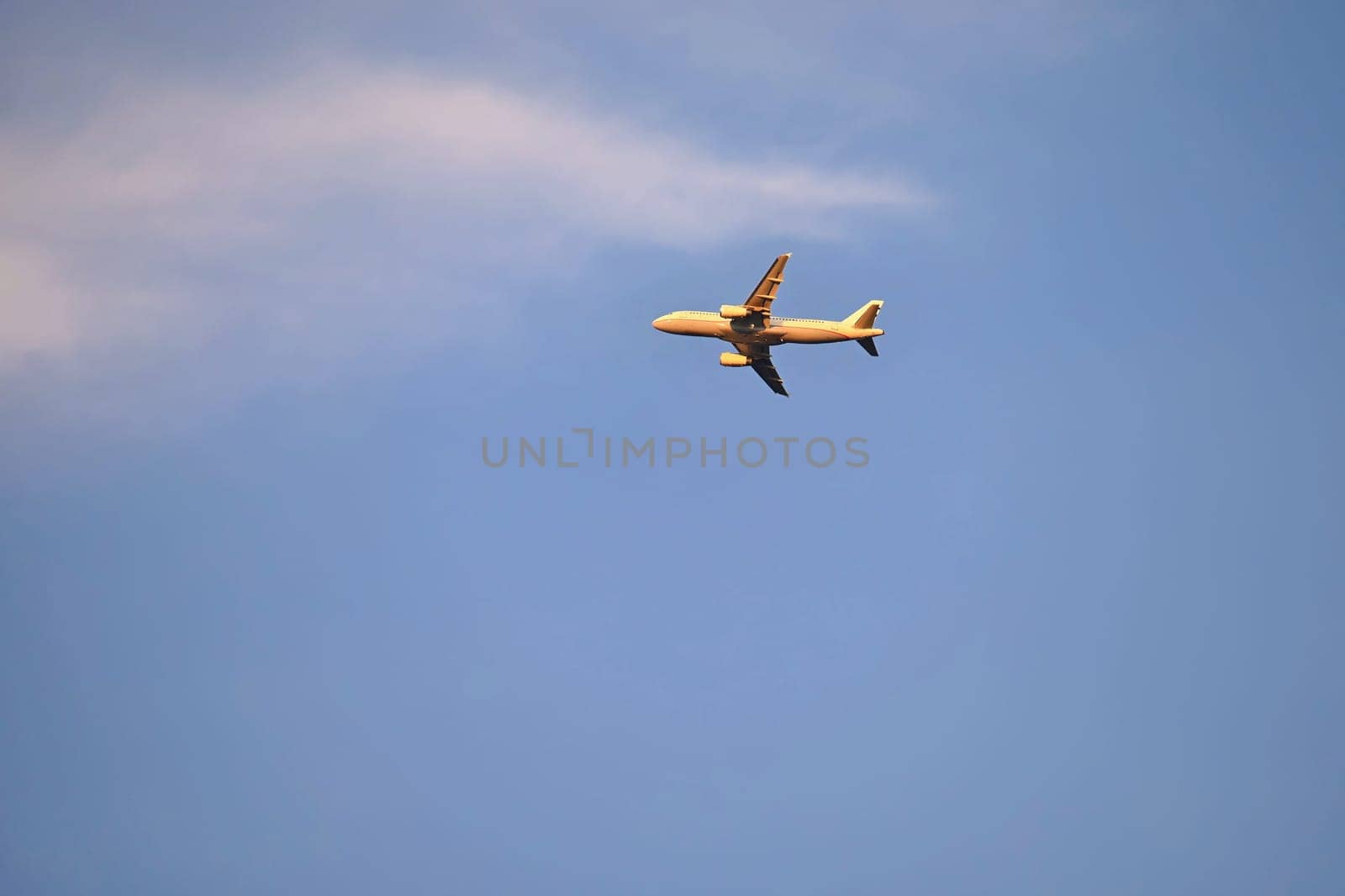 Commercial plane in the blue sky at sunset.
Concept for travel and vacation by air transportation.