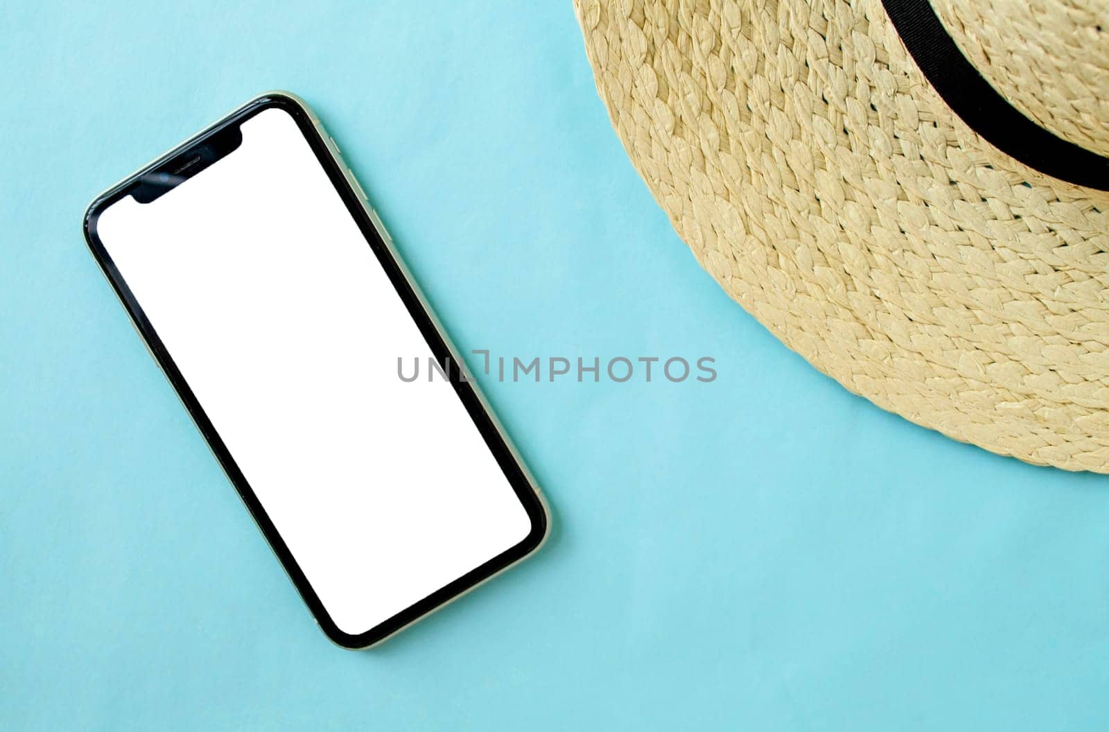 Mockup, smartphone and hat on a blue background. Summer vacation. Background for advertising.