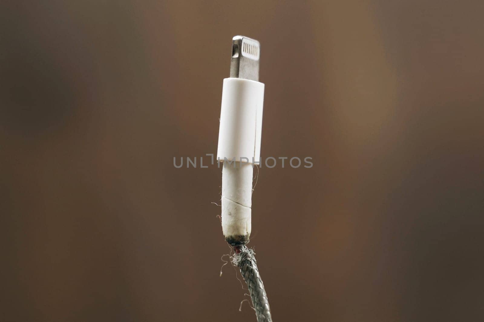 Faulty phone charging wire, wire insulation destroyed. Close-up