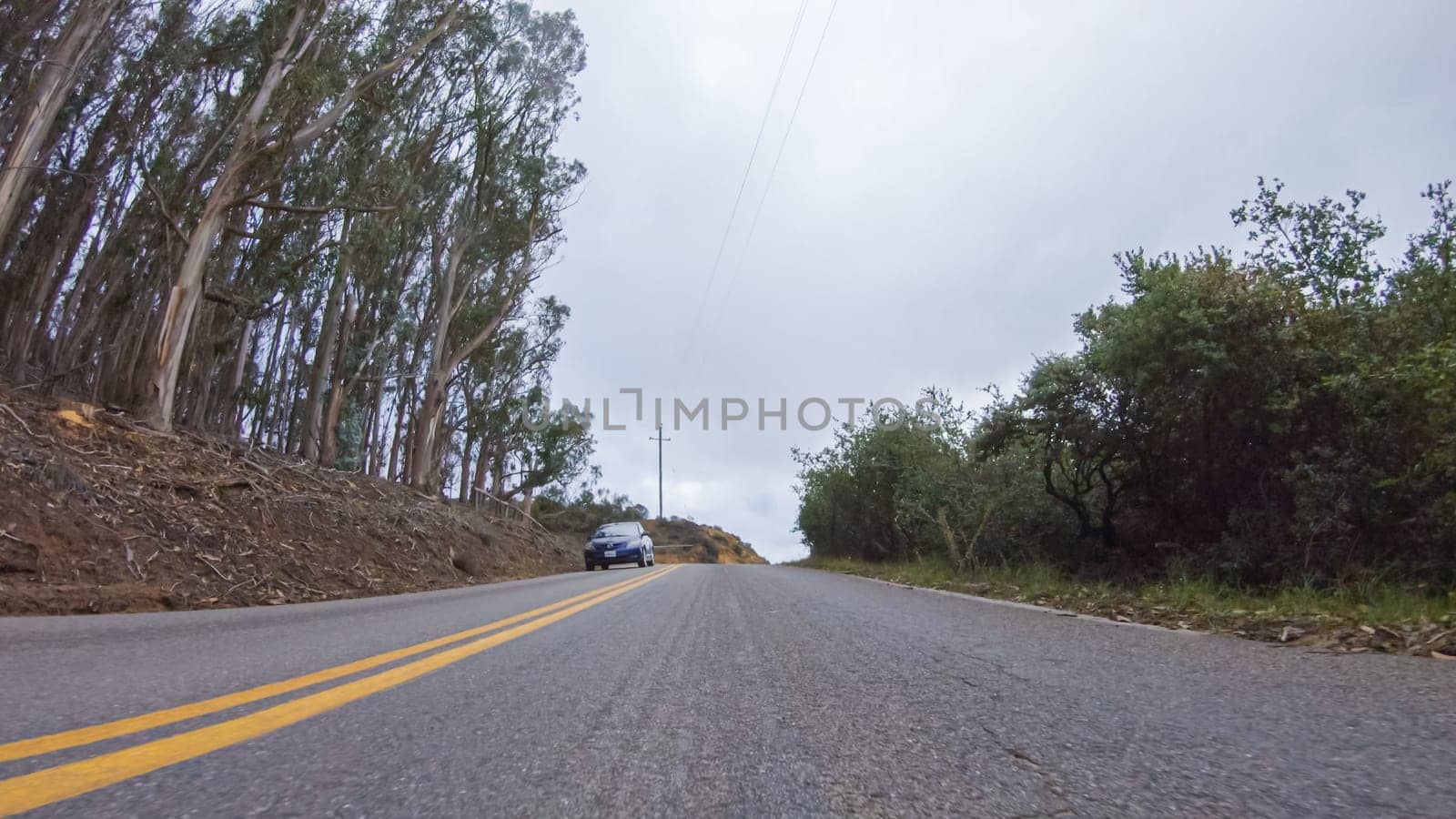 In this serene winter scene, a vehicle carefully makes its way along Los Osos Valley Road and Pecho Valley Road within Montana de Oro State Park.