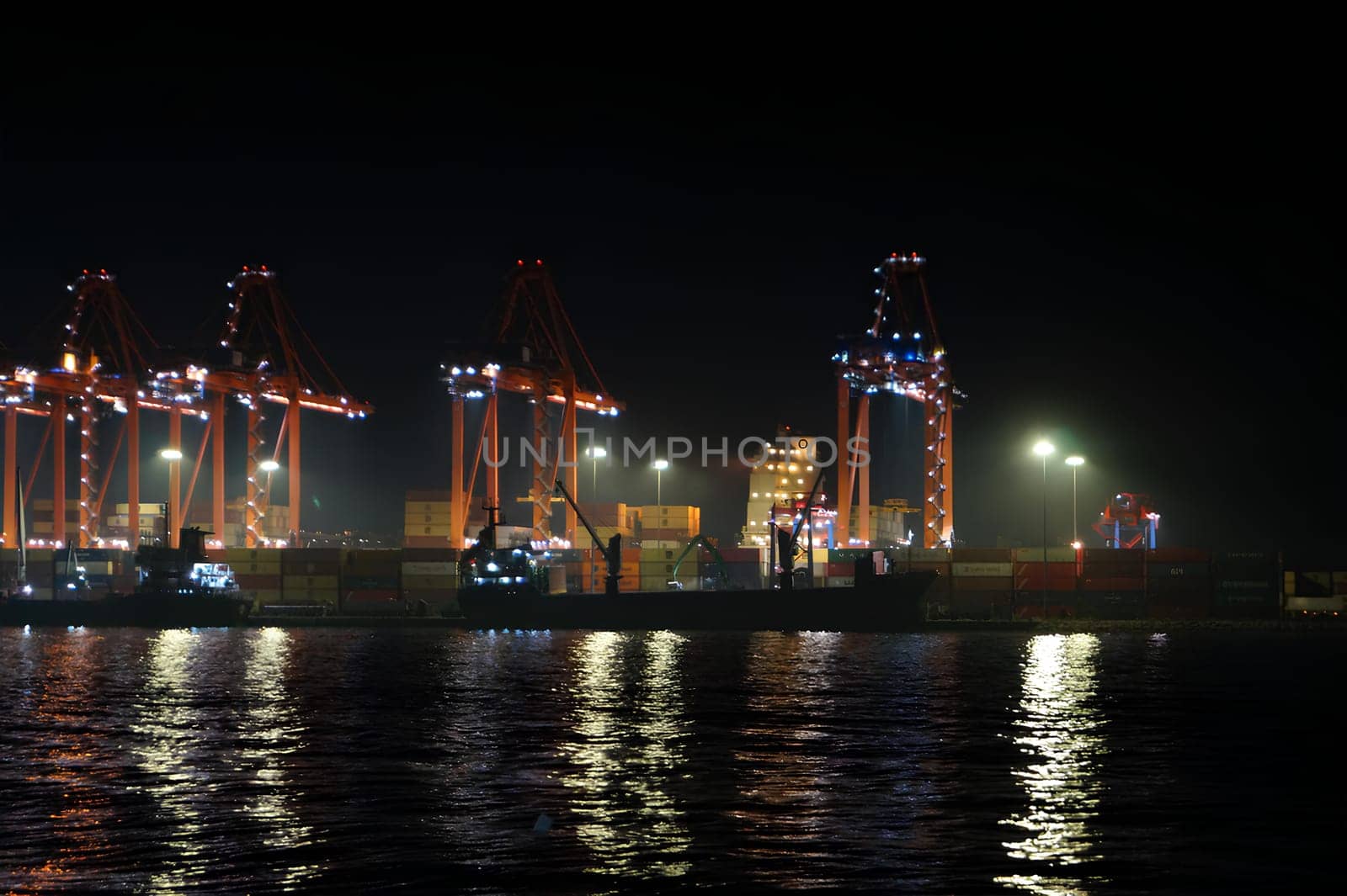 A large ship is docked at a port at night