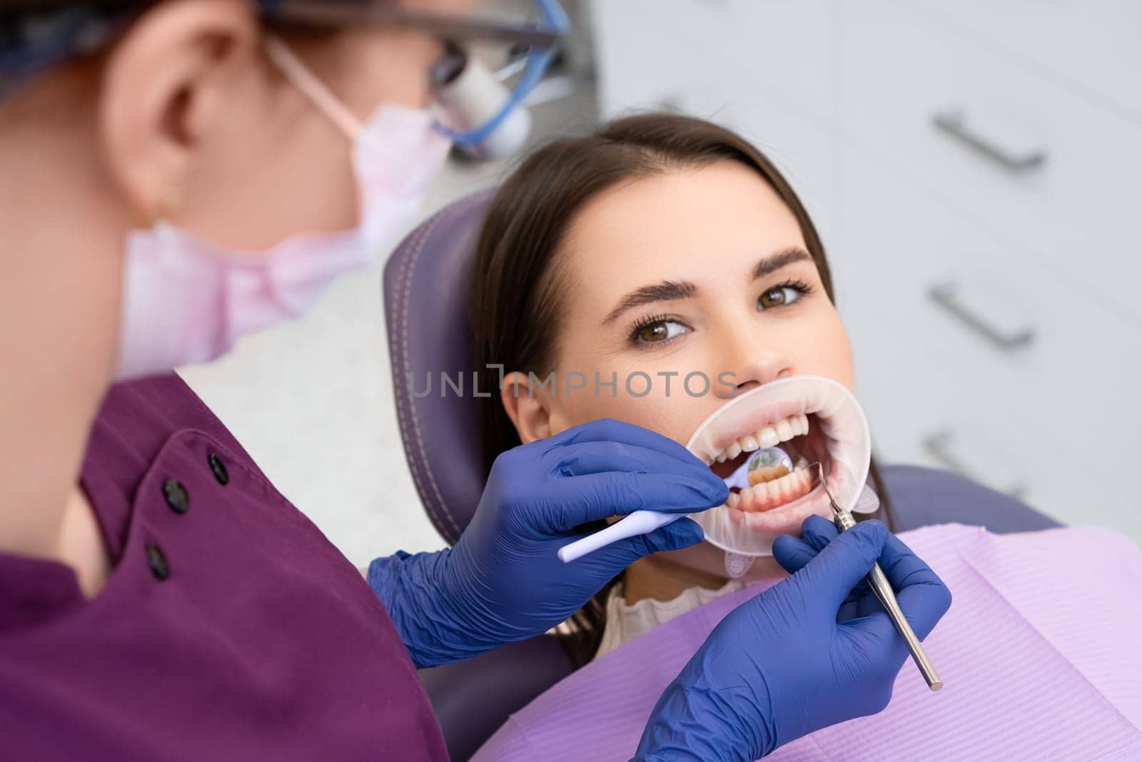 Portrait of satisfied young woman sitting in a dental chair at a dentist office