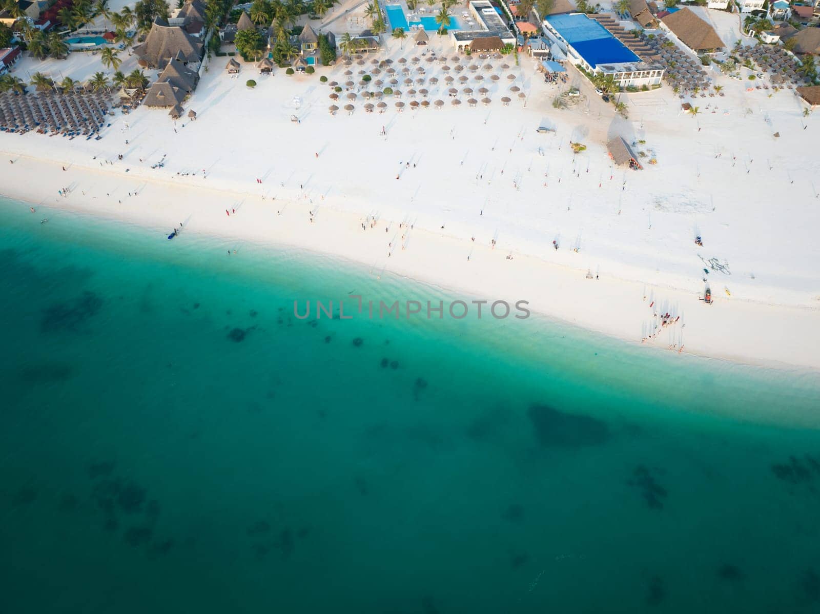 Top view of sandy beach and clear green water in Zanzibar by Robertobinetti70