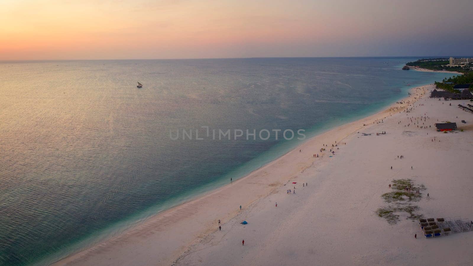 Zanzibar beach at sunset,where tourists and locals mix together of colors and joy, concept of summer vacation, aerial view of Kendwa beach, Tanzania