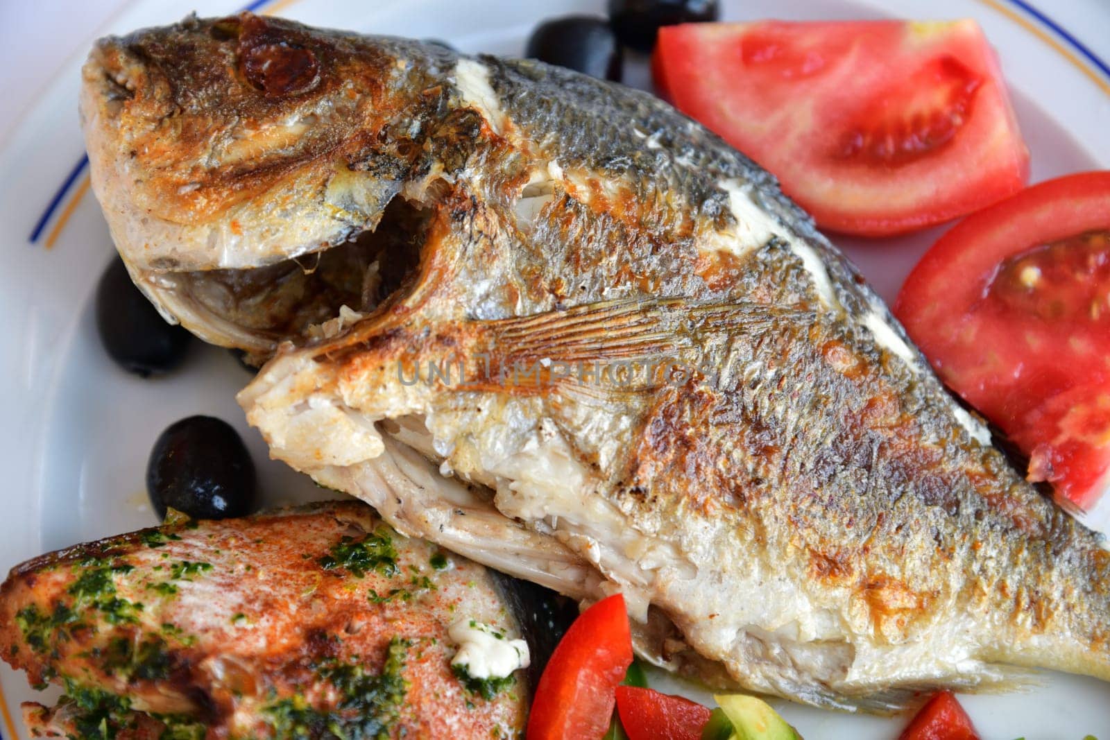 Fried river fish carcass with vegetables