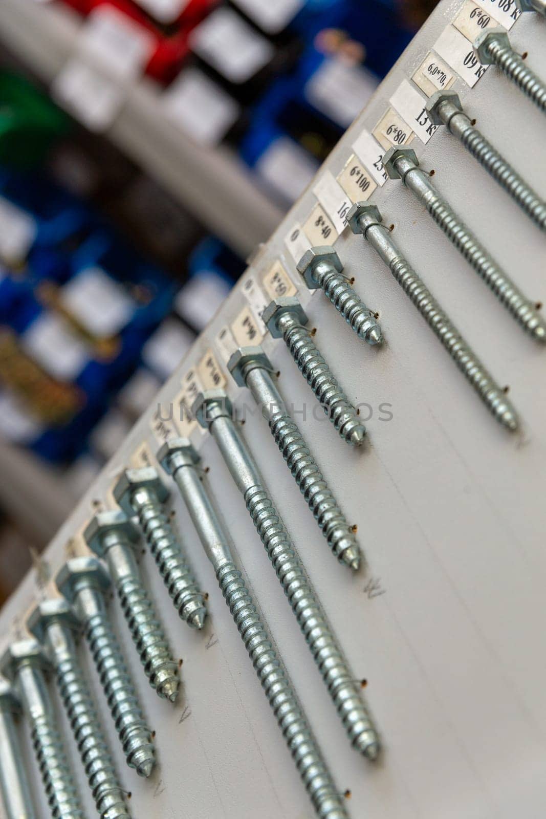 An assortment of screws with sizes and prices on the stand in the hardware store