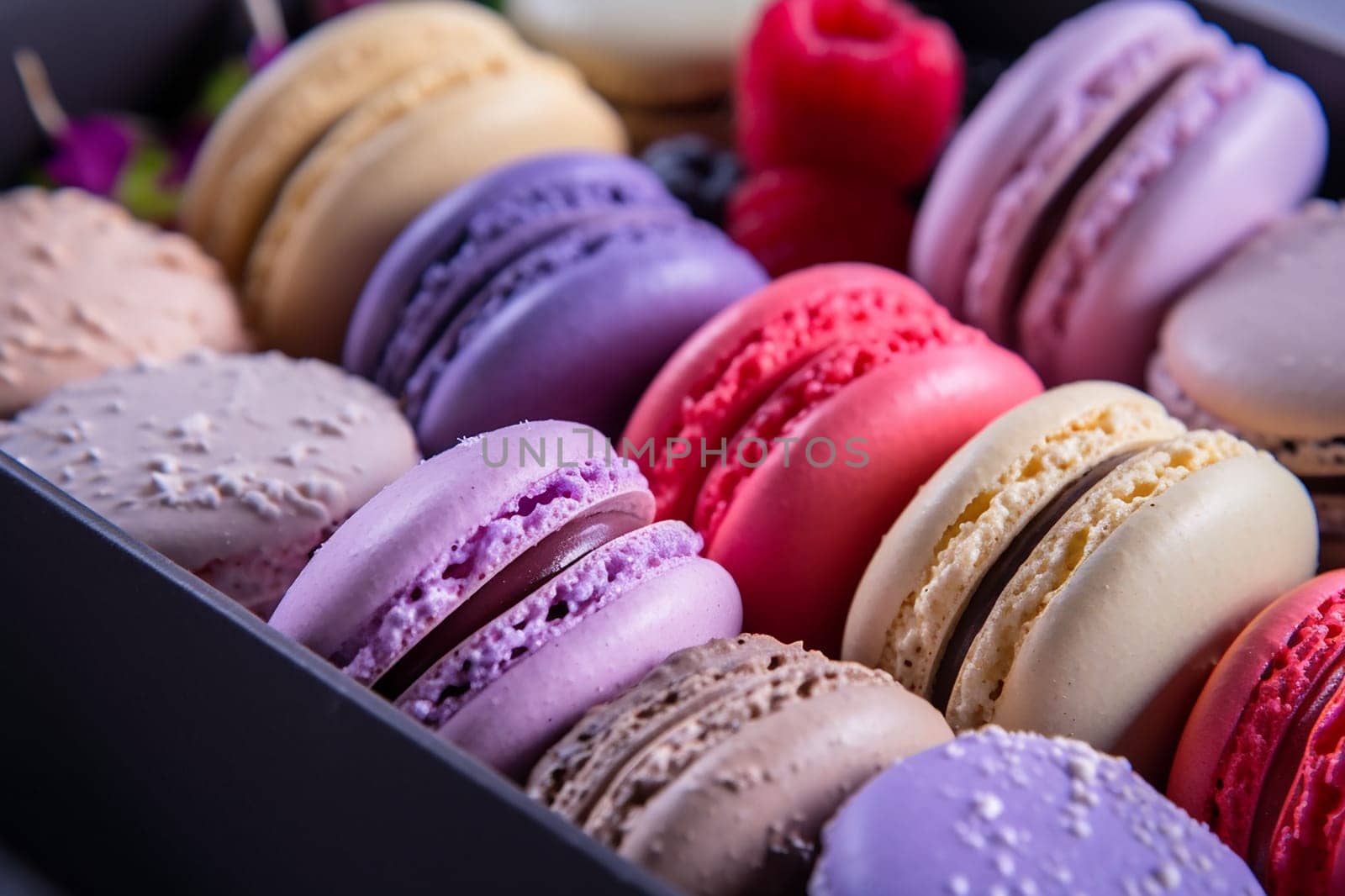 Assorted colorful macarons arranged neatly in a box by Hype2art