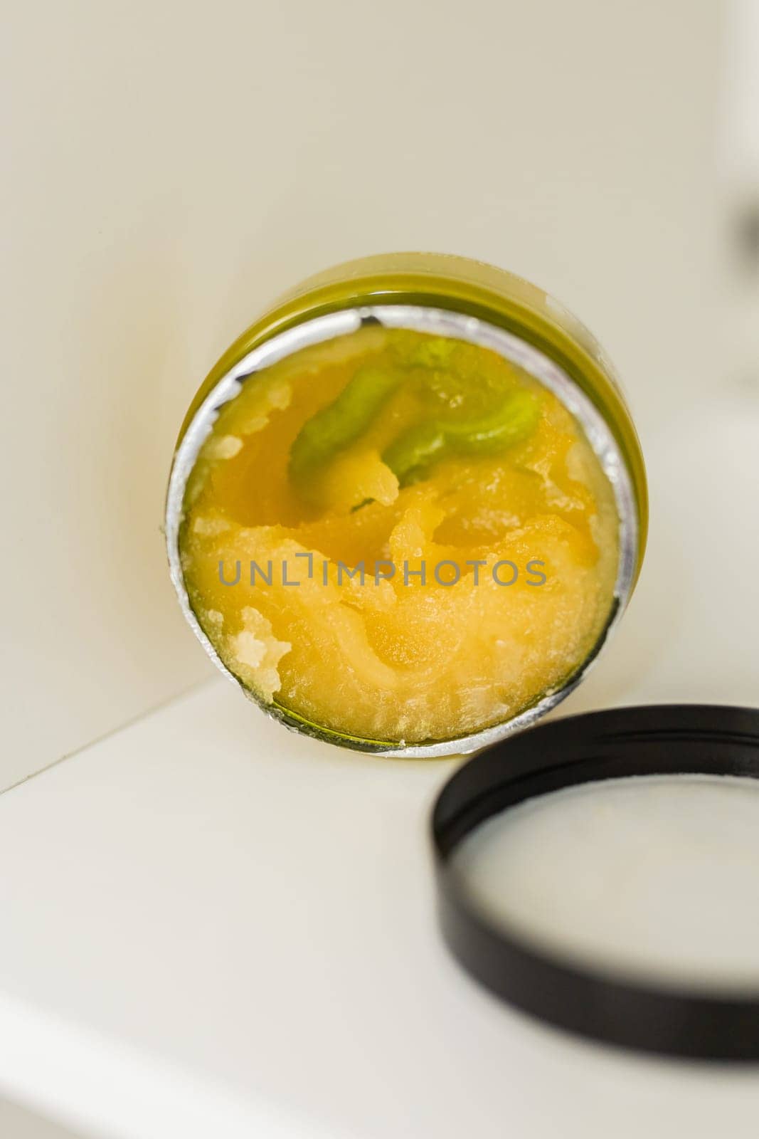 Orange body scrub with sugar and oil in glass jar copy space. Homemade cosmetic for peeling and spa care. by Satura86