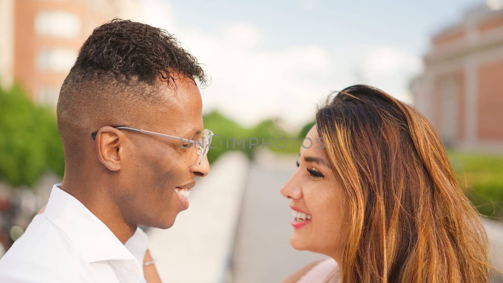 Multiethnic couple looking at each other smiling by ivanmoreno