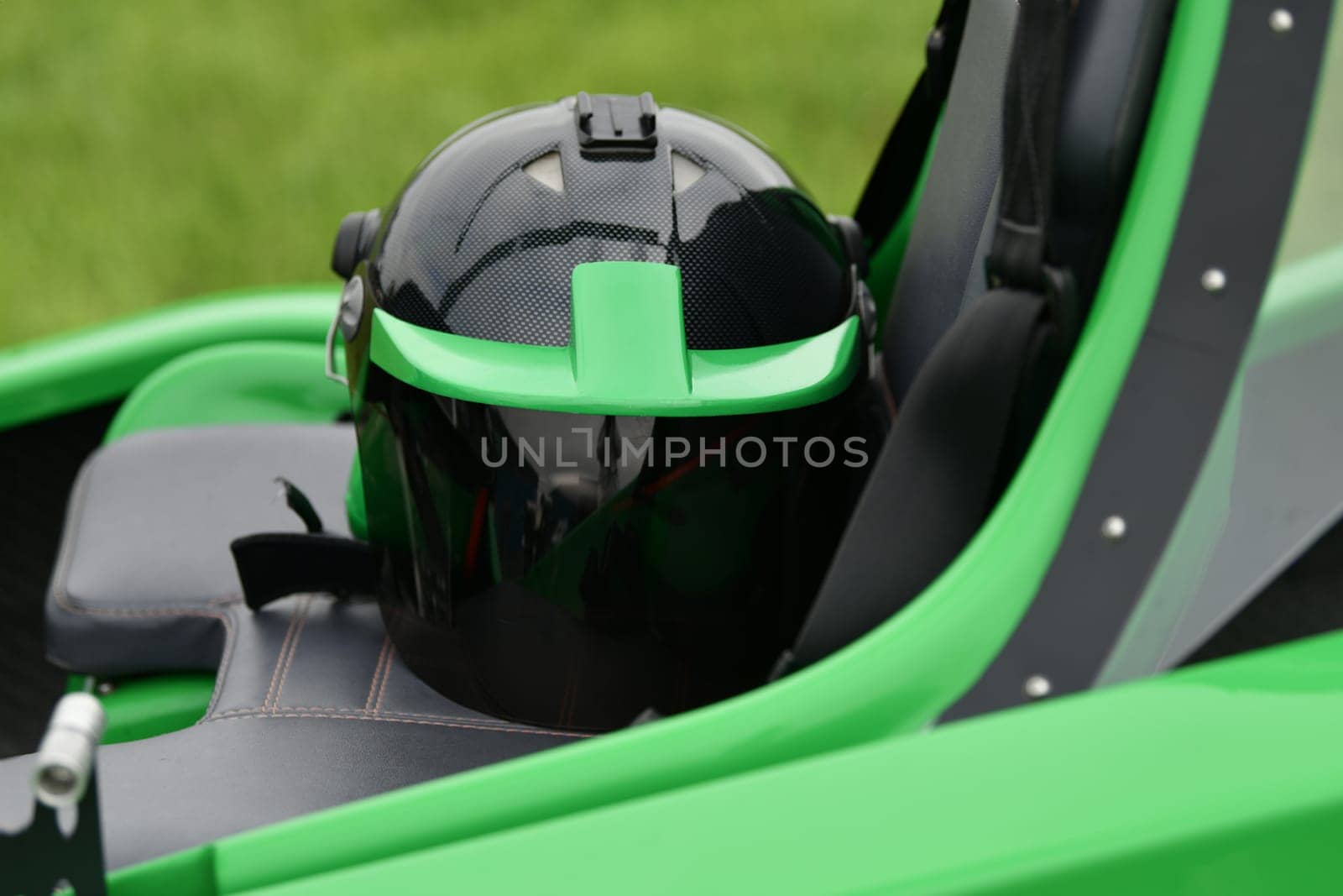 Helmet on a two-seater green gyrocopter at the airfield by Godi