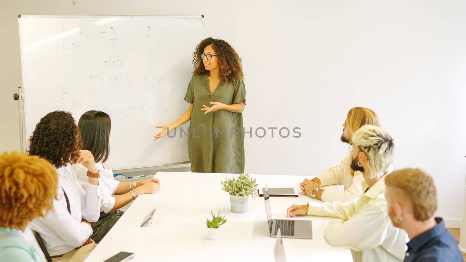 Woman using board while explaining a project in a meeting by ivanmoreno