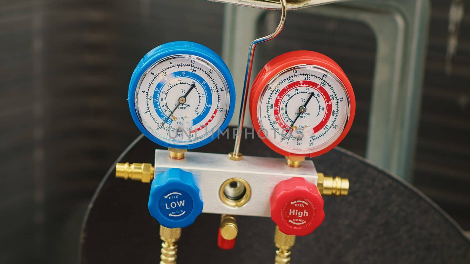 Close up shot of professional ac gauges vacuum pump used for checking HVAC system freon. Set of manometers showing high or low refrigerant levels in external air conditioner