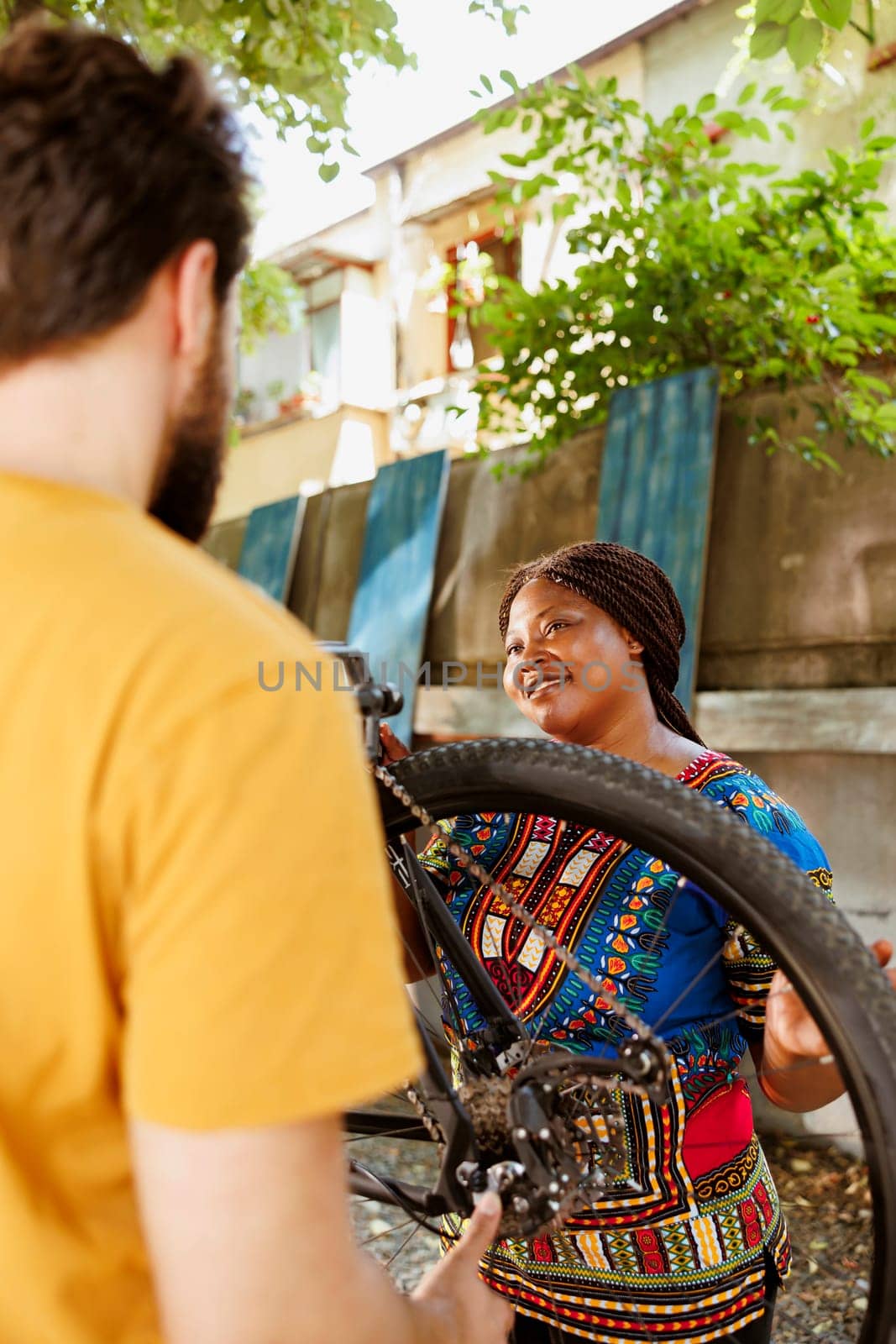 Black woman checking for bike damages by DCStudio