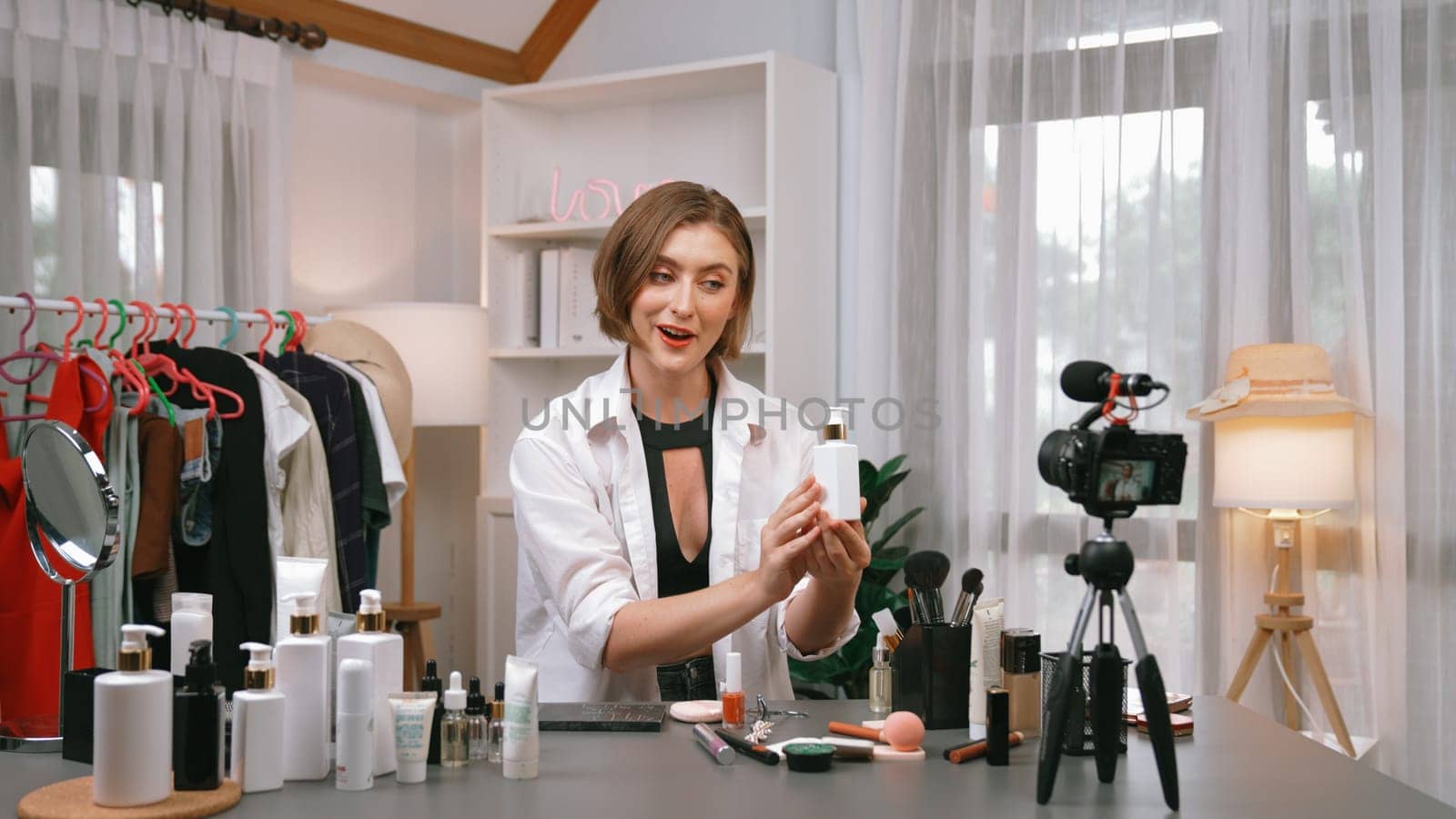 Woman influencer shoot live streaming vlog video review skincare for prim social media or blog. Happy young girl with cosmetics studio lighting for marketing recording session broadcasting online.