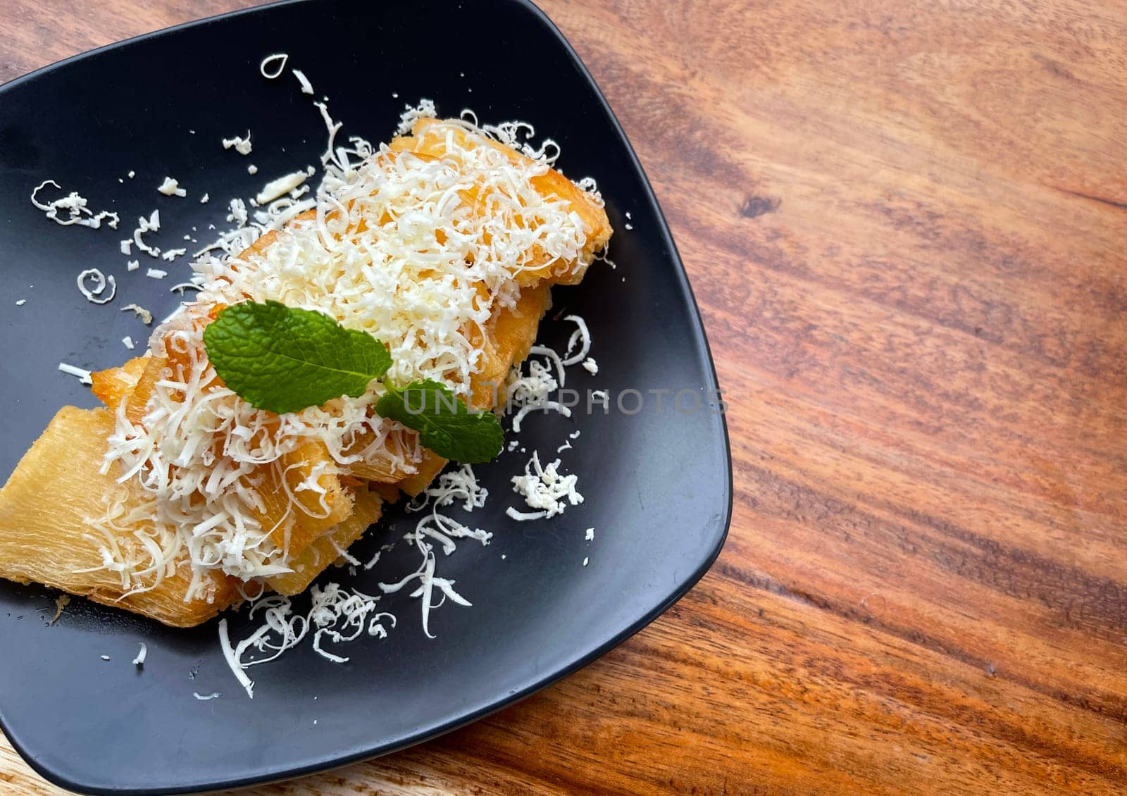 fried cassava with topping cheese on top, Indonesian traditional food, good for tea time or snack