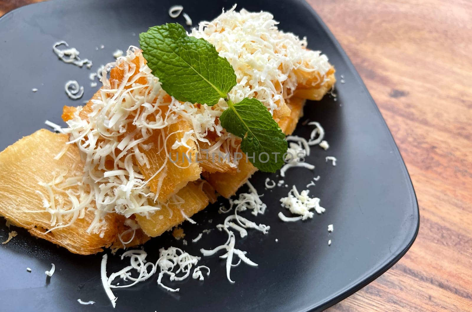 fried cassava with topping cheese on top, Indonesian traditional food, good for tea time or snack