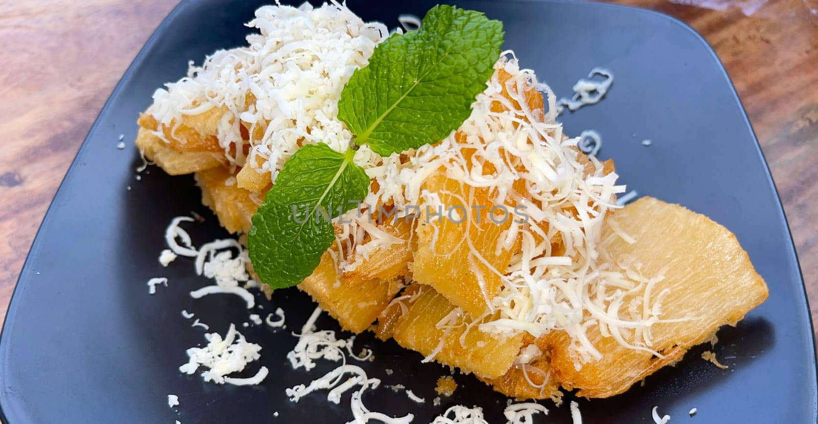 fried cassava with topping cheese on top, Indonesian traditional food, good for tea time or snack