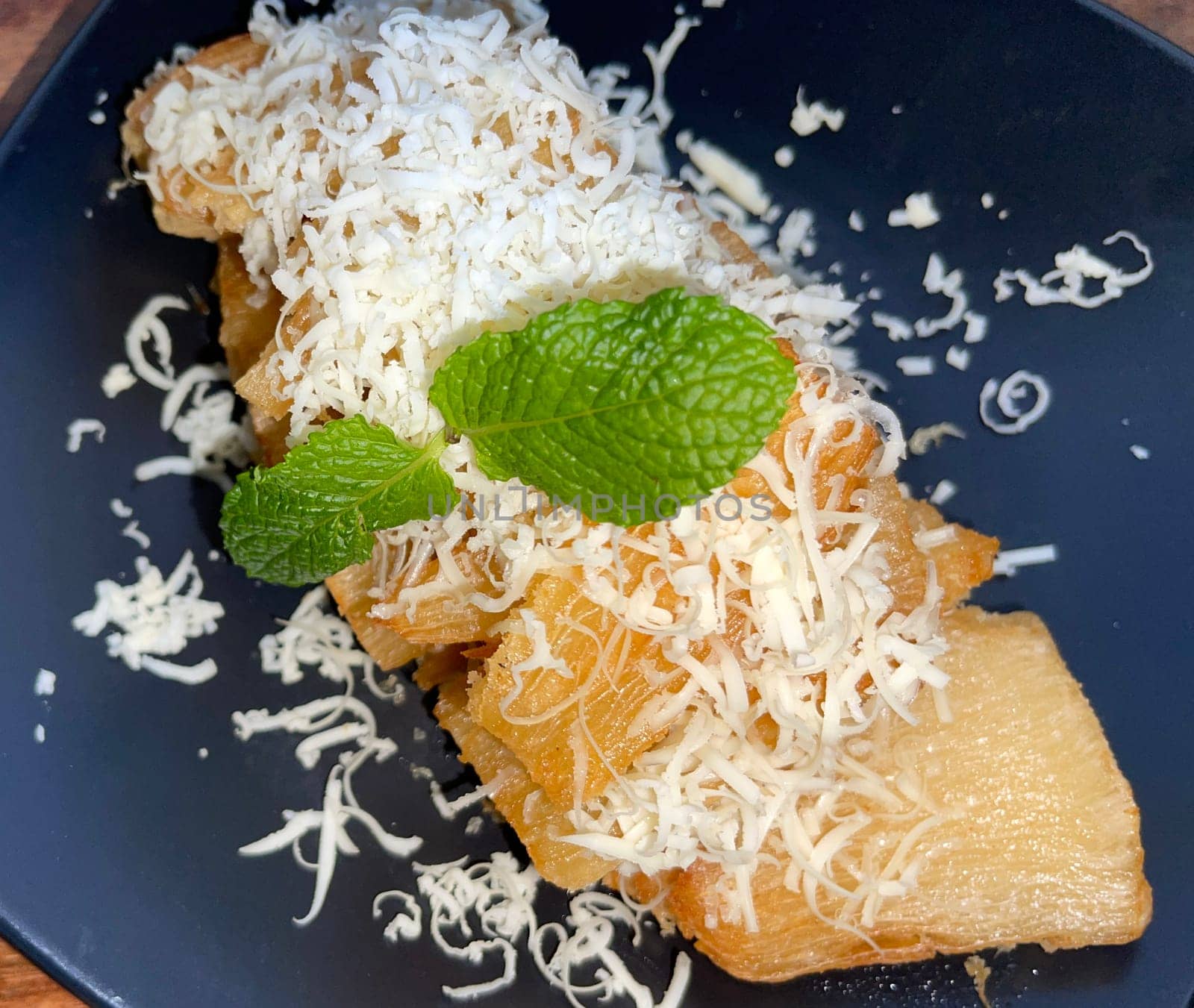 fried cassava with topping cheese on top, Indonesian traditional food, good for tea time or snack