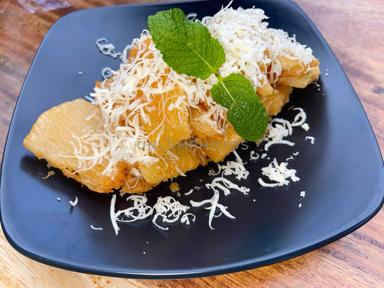 fried cassava with topping cheese on top, Indonesian traditional food, good for tea time or snack