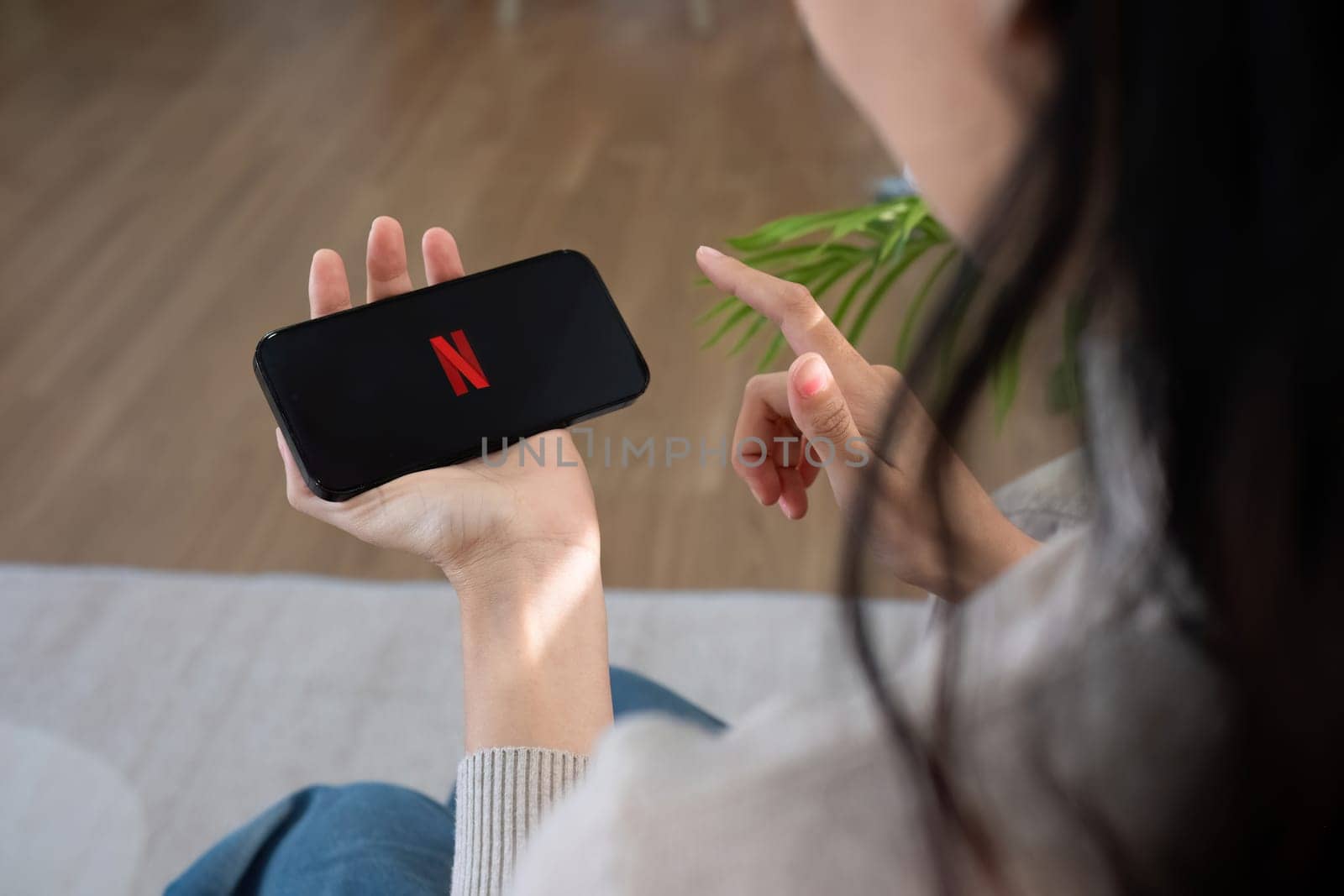 CHIANG MAI, THAILAND FEB 27, 2024: Netflix logo on iPhone 14 screen. Netflix is an international leading subscription service for watching TV episodes and movies by wichayada