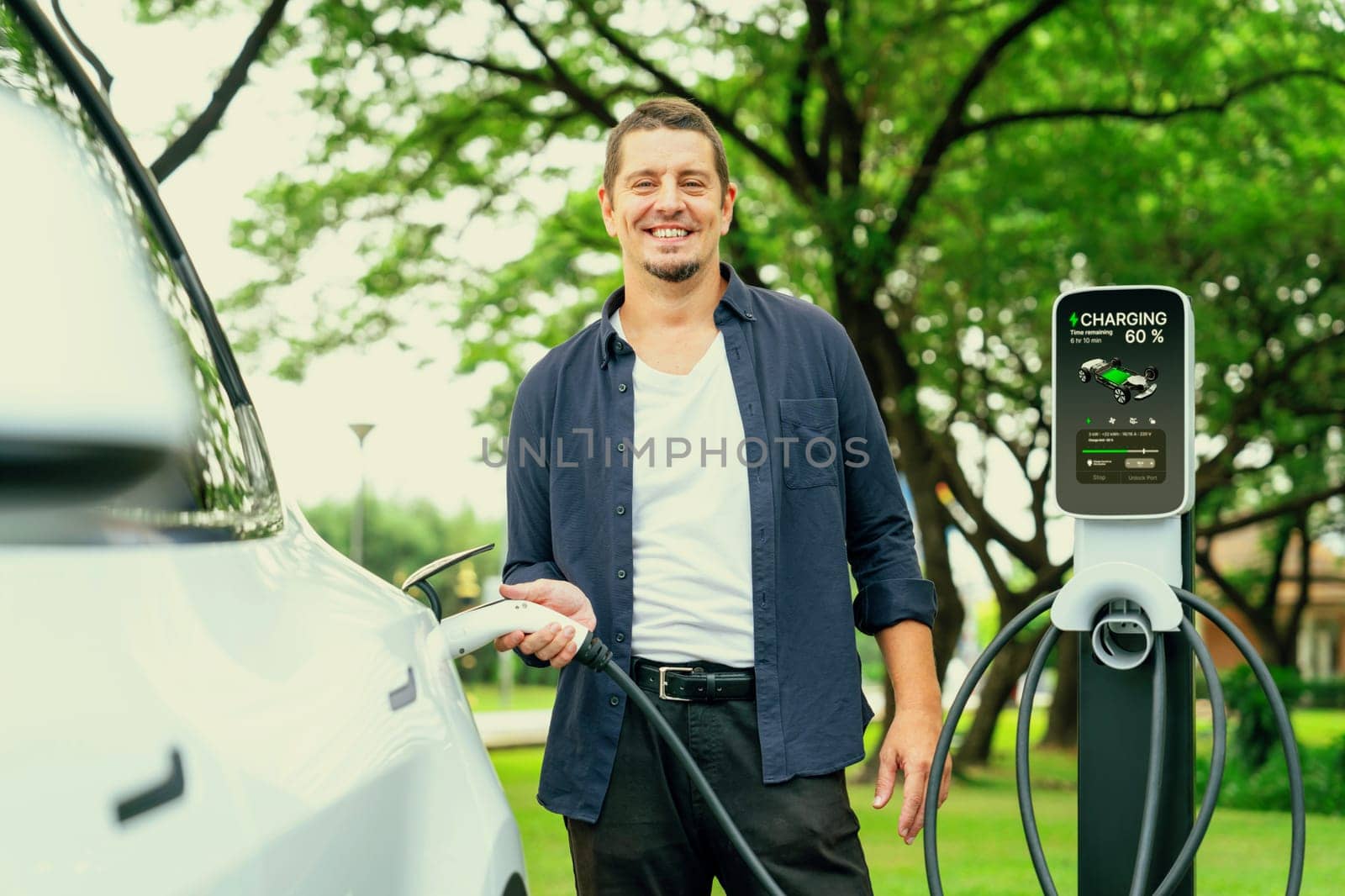 Man recharge EV electric vehicle battery from EV charging station. Exalt by biancoblue