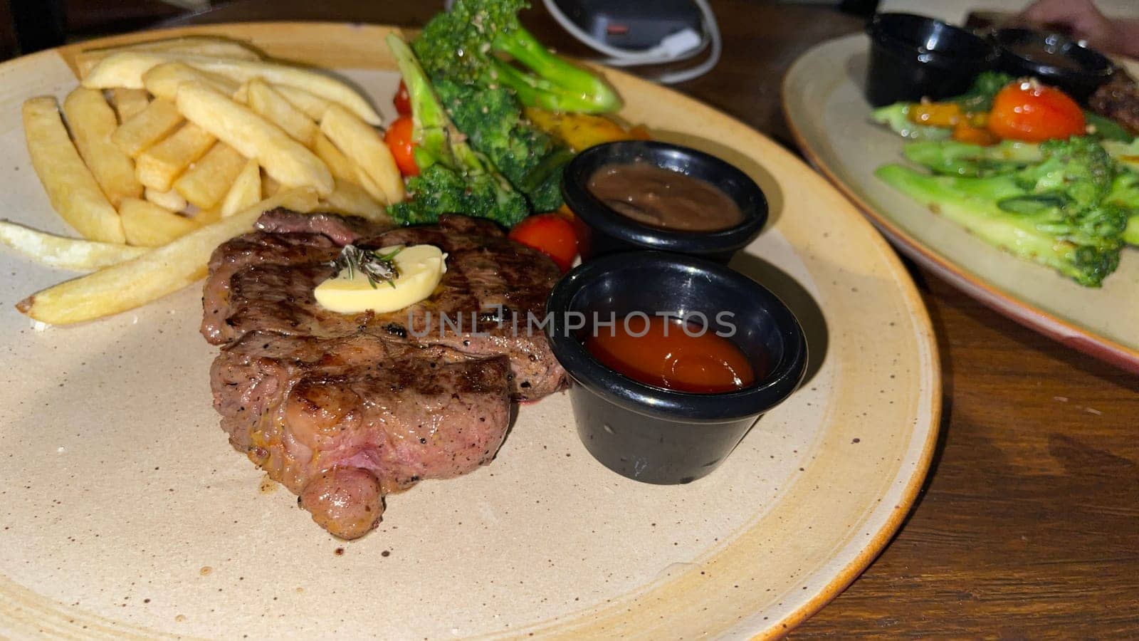 Juicy beef steak with salad and mashed potato along with pepper corn sauce served on wooden plate wooden stone table. Top view on a restaurant