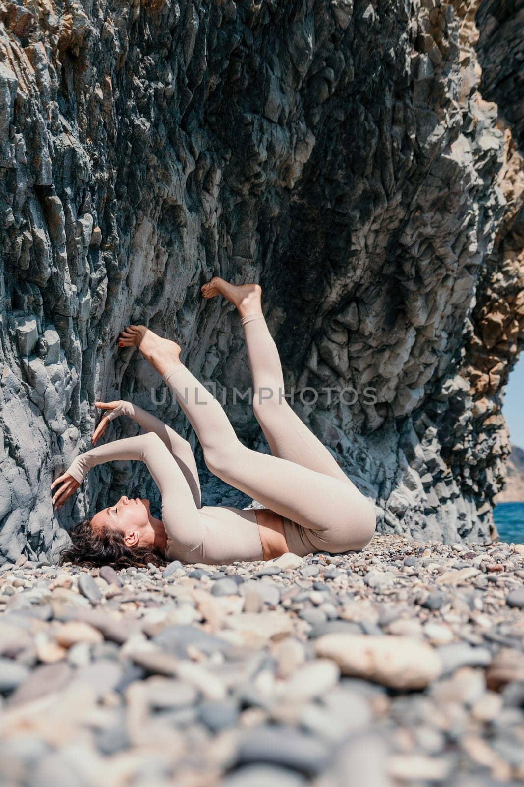 Woman travel sea. Sporty happy middle aged posing on a beach near the sea on background of volcanic rocks, like in Iceland, sharing travel adventure journey by panophotograph